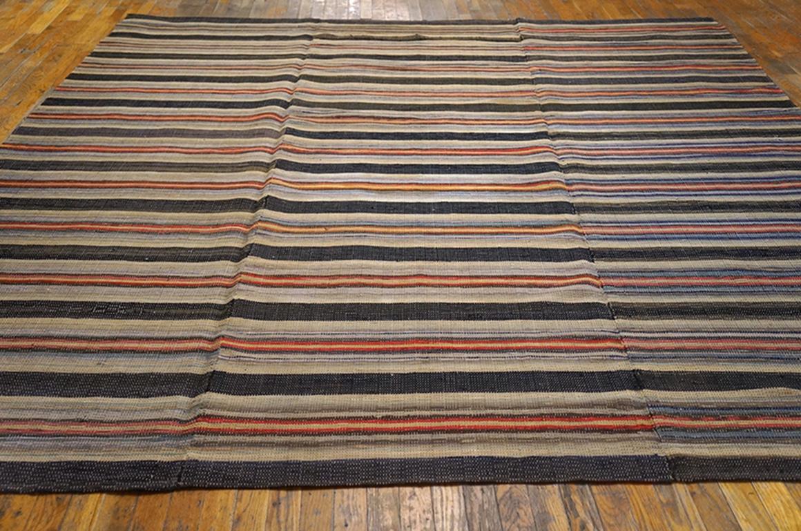 An American specialty, rag rugs are flat-woven with sections of rags from worn out clothing or furnishings worked in a horizontal stripe design. This particularly large example was made in three vertical sections and then joined by sewing. Black,