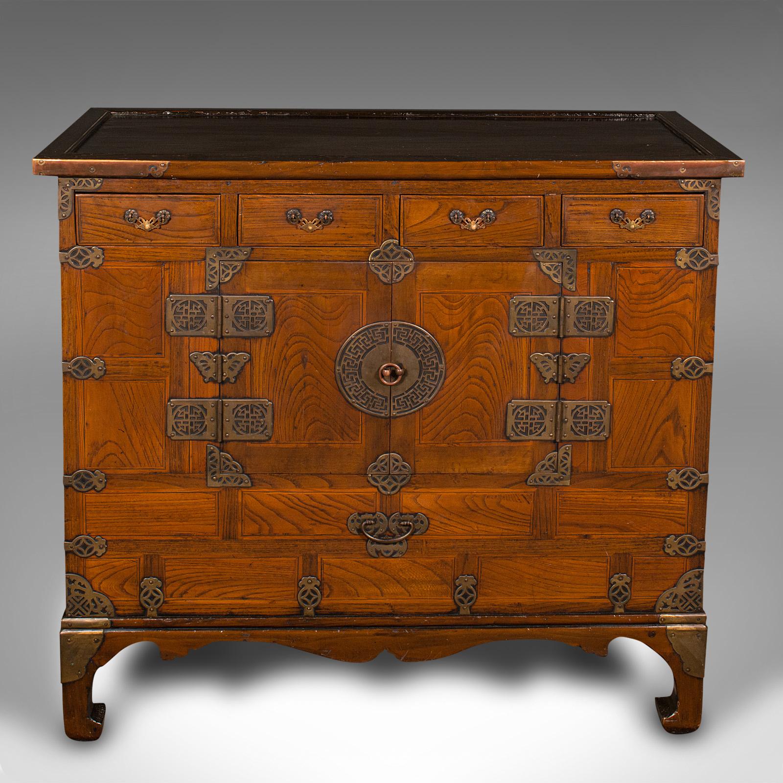 This is an antique raised chest. A Korean, elm and pear wood side cabinet with brass fittings, dating to the late Victorian period, circa 1880.

Superb Korean craftsmanship with delightful brass tones
Displaying a desirable aged patina and in good