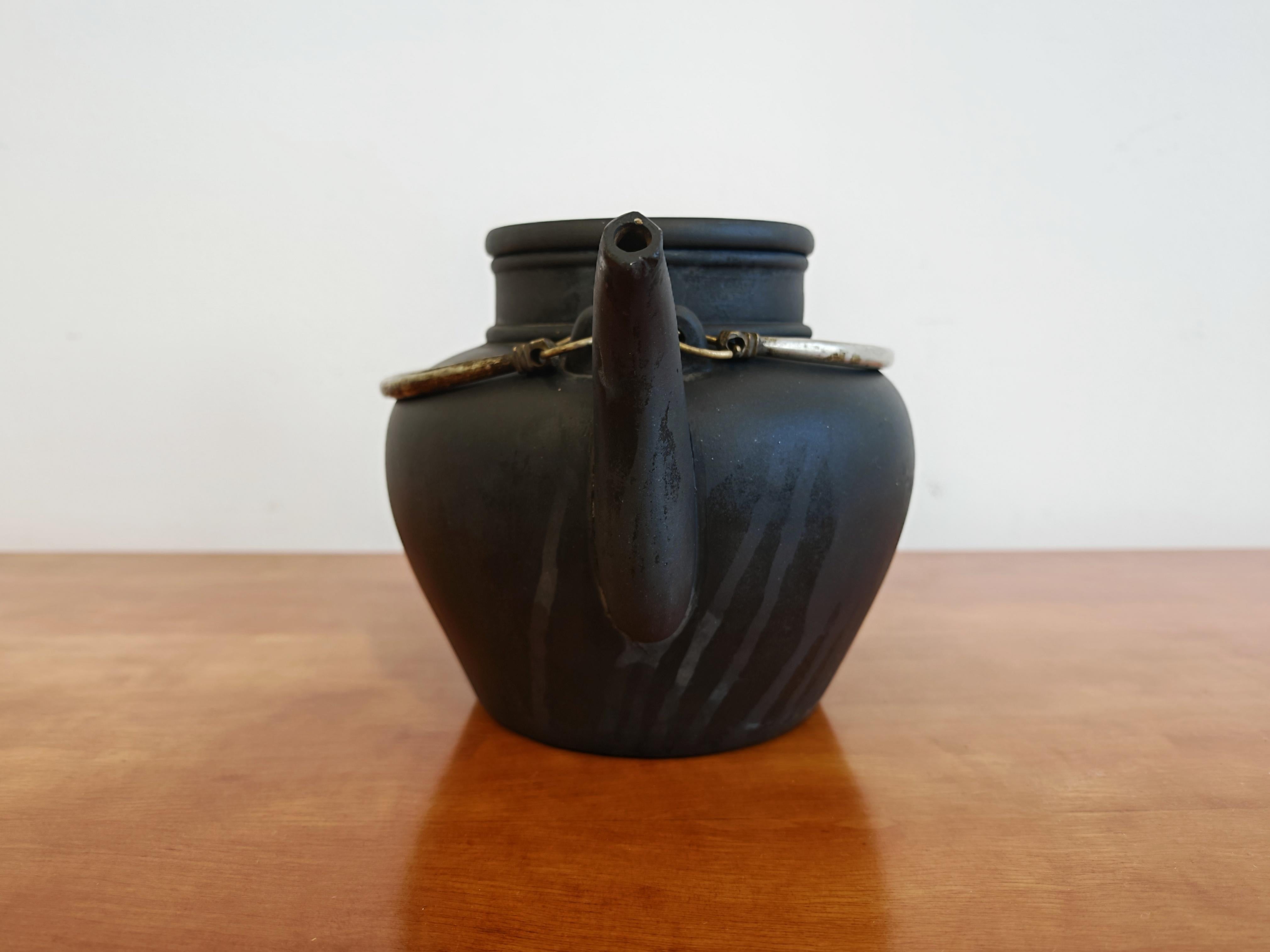 Dans cette annonce, vous trouverez une théière ancienne en céramique, réalisée en argile noire. Il s'agit d'une théière Yixing fabriquée sous la dynastie Qing. Le carré indique le lieu 营口 (Yinkow) au sommet, qui est un port maritime de la province