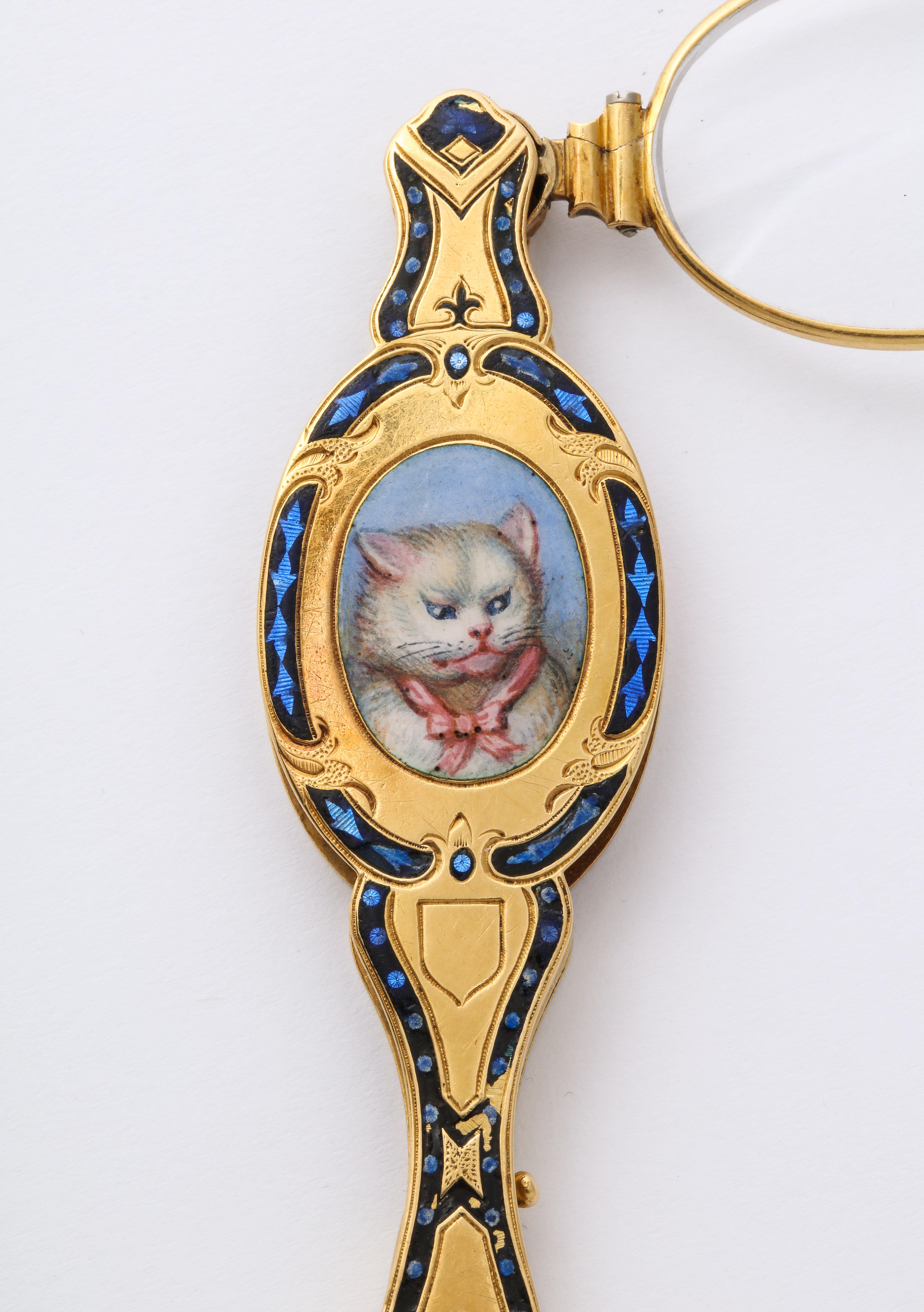 Rare as a needle in a haystack, a luxurious two sided lorgnette in 18 Kt gold and enamel, one side an enamel painting of a suspicious feline in white with blue eyes, while on the other side a scrolling vine and floral all over pattern. Your eye