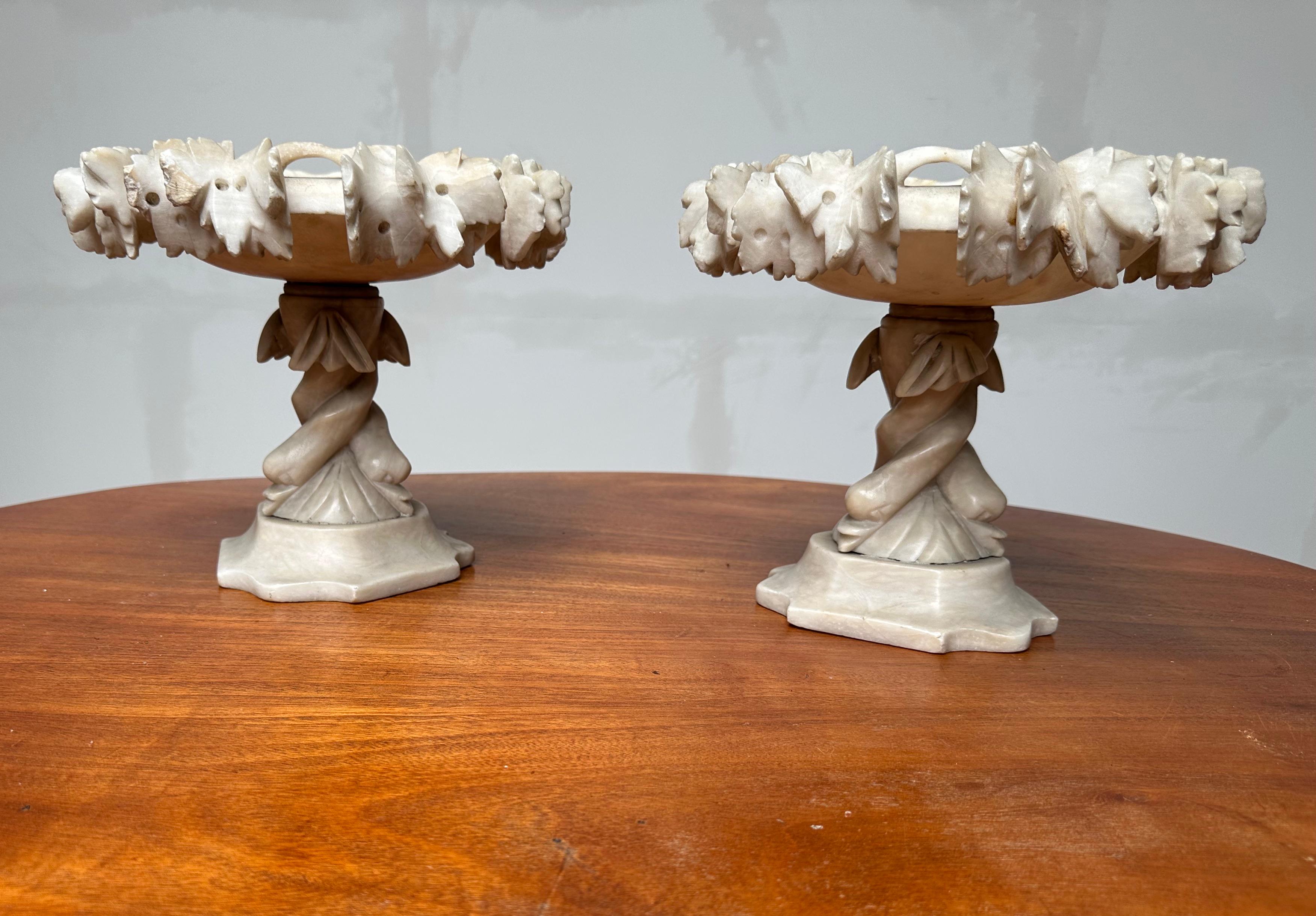 All handcrafted out of alabaster these stylish & decorative tazzas make great centrepieces.

This rare pair of early 1900s tazzas comes with overhanging wine branches all around the circular tops. Finding this pair of Renaissance Revival tazzas more
