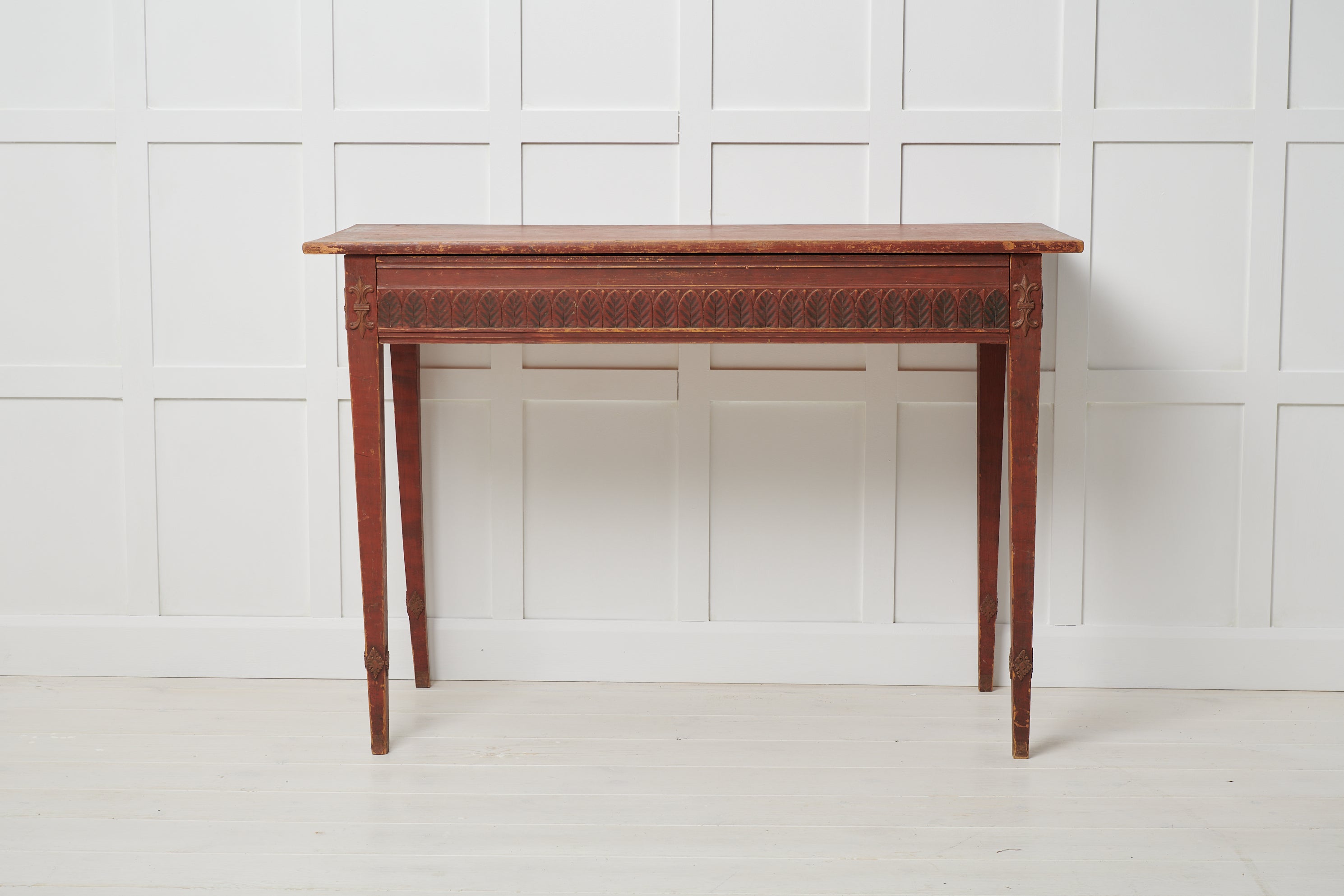 Rare antique console table in Gustavian Style from Sweden. The table is from the first years of the 19th century, around 1800 to 1810. The table is made by hand in solid pine with a handcrafted decor in the shape of leaves that wraparound the apron.