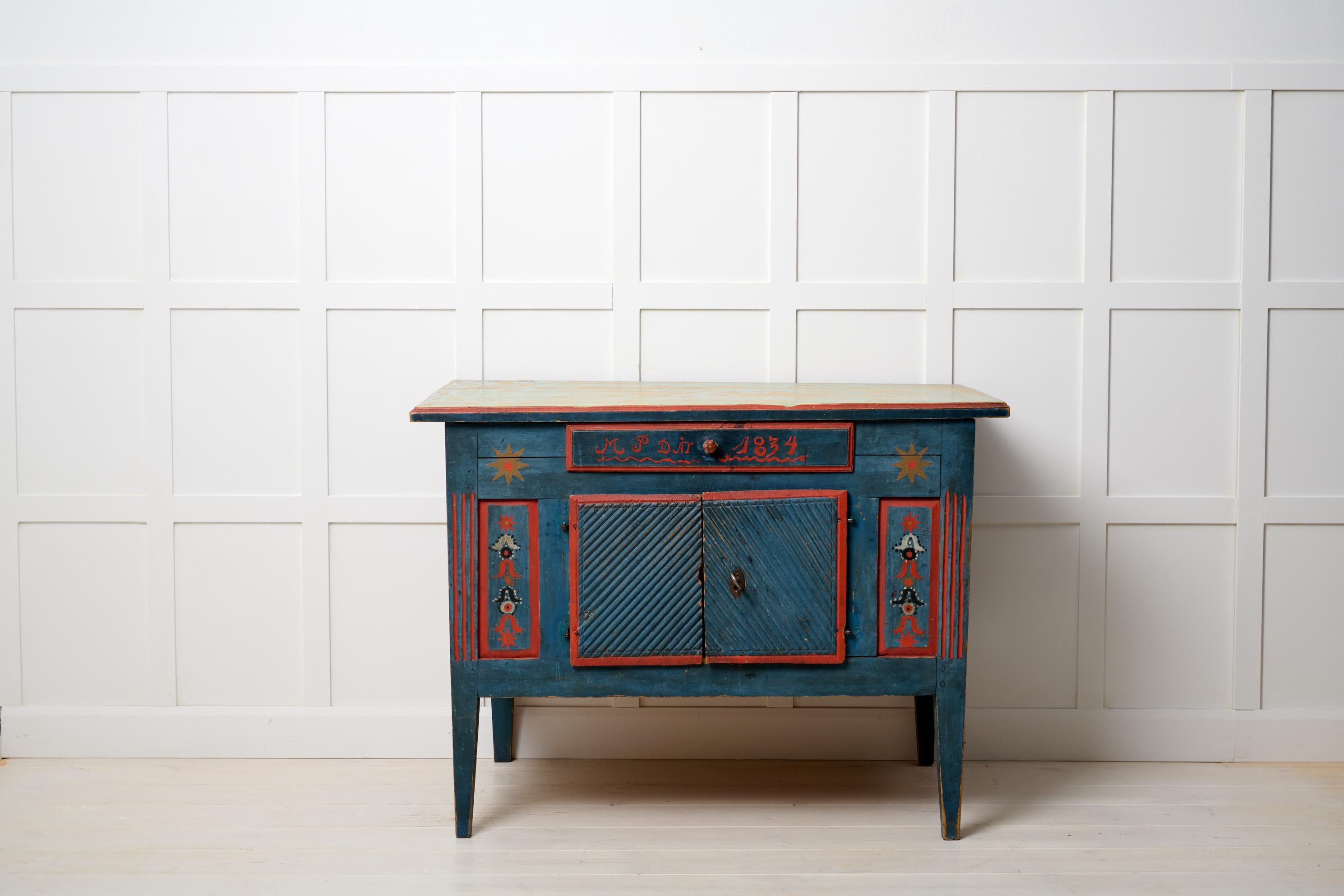 Rare antique Swedish sideboard. The sideboard is unusually low and made in gustavian style. It is an authentic country house furniture from 1834 made in Hälsingland. The frame is made by hand in solid pine. Original blue and red paint with initials
