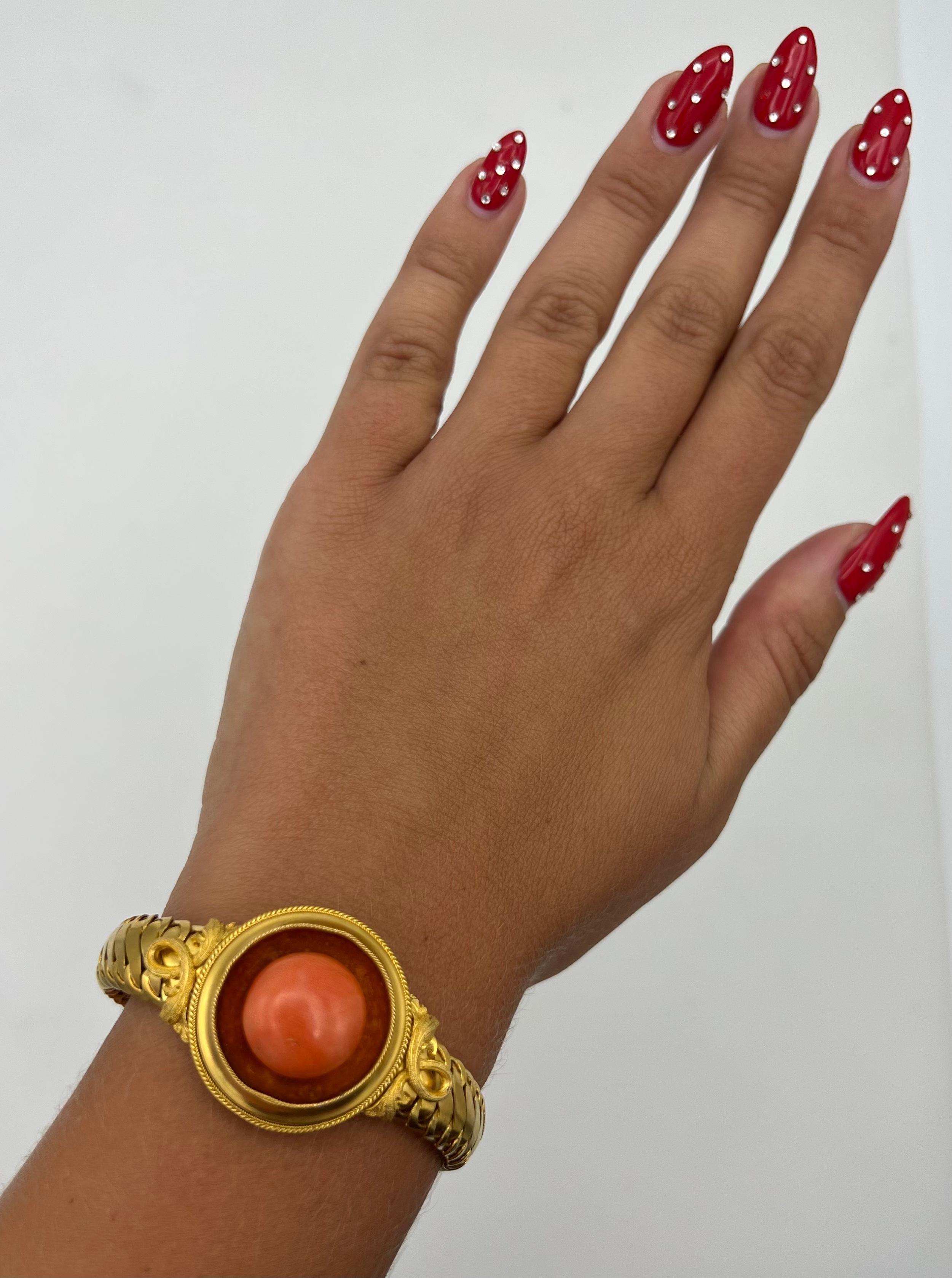 - 14 karat yellow gold
- Cabochon coral, approx 15.20 mm 
- Featuring chain finish bracelet 
- Boxed in clasp closure with safety chain 

Total weight is 37.4 grams.
Measurments 6.5 inches long and 1 inch wide.
Hallmarks: maker’s mark RD.