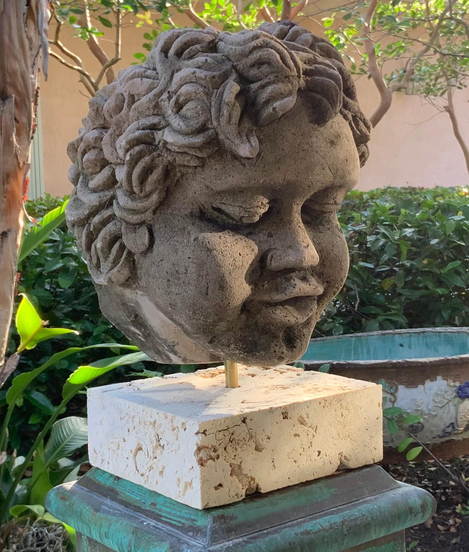 Exceptional large cherub head made of hand carved sand stone, professionally mounted on genuine coral base. Beautiful facial expression, this piece was originally used as wall-mounted fountains head, converted to one of a kind object of art for
