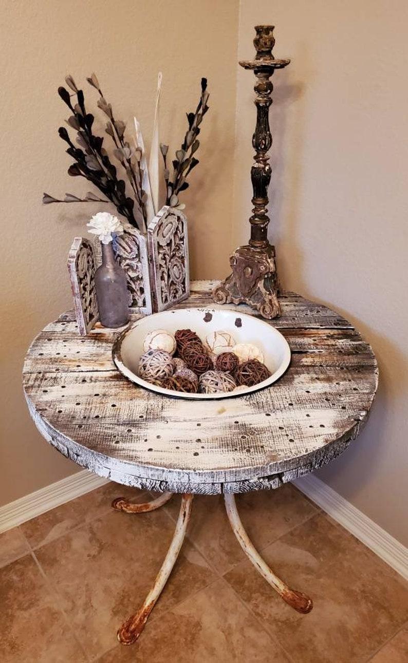A truly unique, one-of-a-kind antique center table, hand crafted from a vintage distressed and antiqued wooden spool/reel, a removable 19th century white painted cast iron bowl insert, all rising on a base of four rusty and heavily patinated antique
