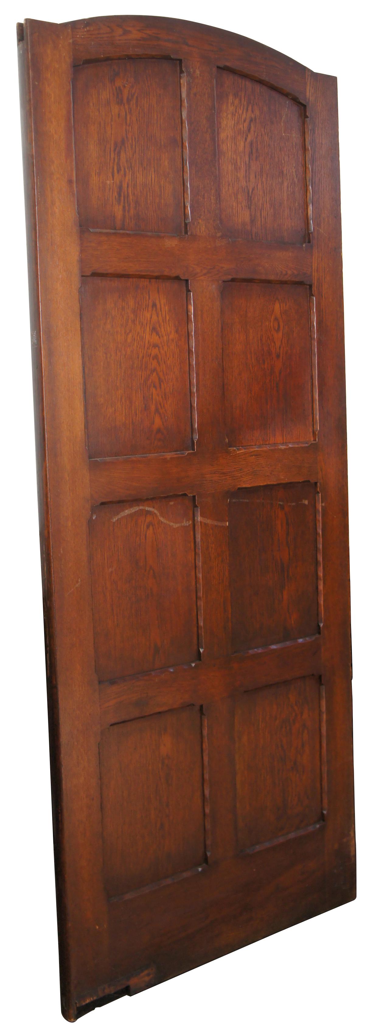 Early 20th century oak reclaimed swinging butler or kitchen door. Features eight panels in a grid pattern with Spanish Revival design and hardware along one side. Comes from one of the first homes built in oakwood, Ohio by Harry I Schenck, circa