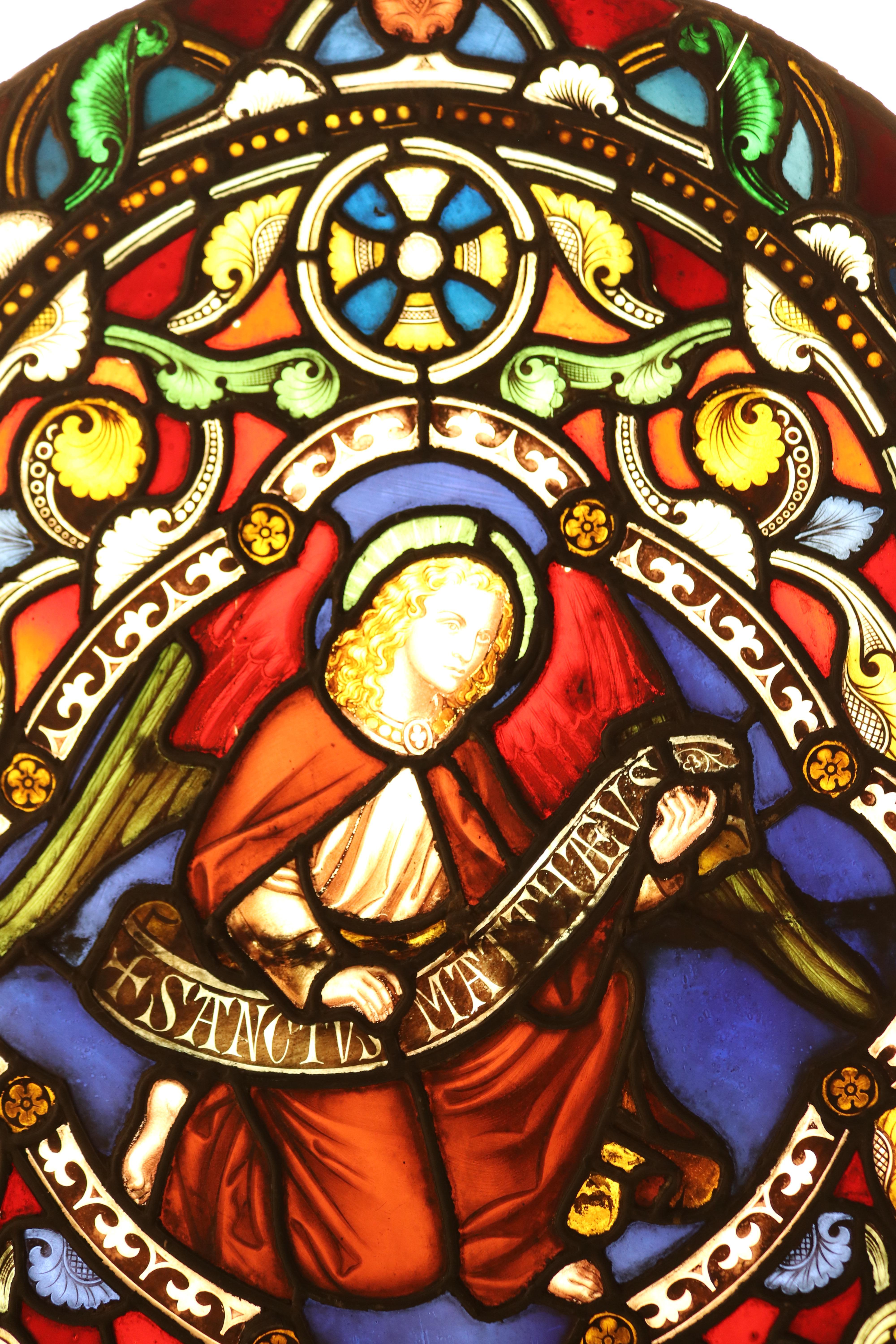 A reclaimed arched stained glass window from a church, depicting an angel.