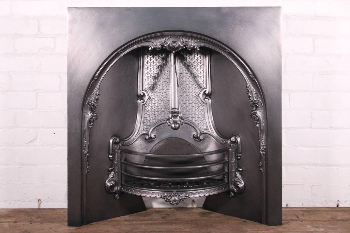 Antique ornate reclaimed Victorian cast iron arched fireplace insert, circa 1850. Fully restored and finished with traditional black grate polish.

Measure: Overall 34