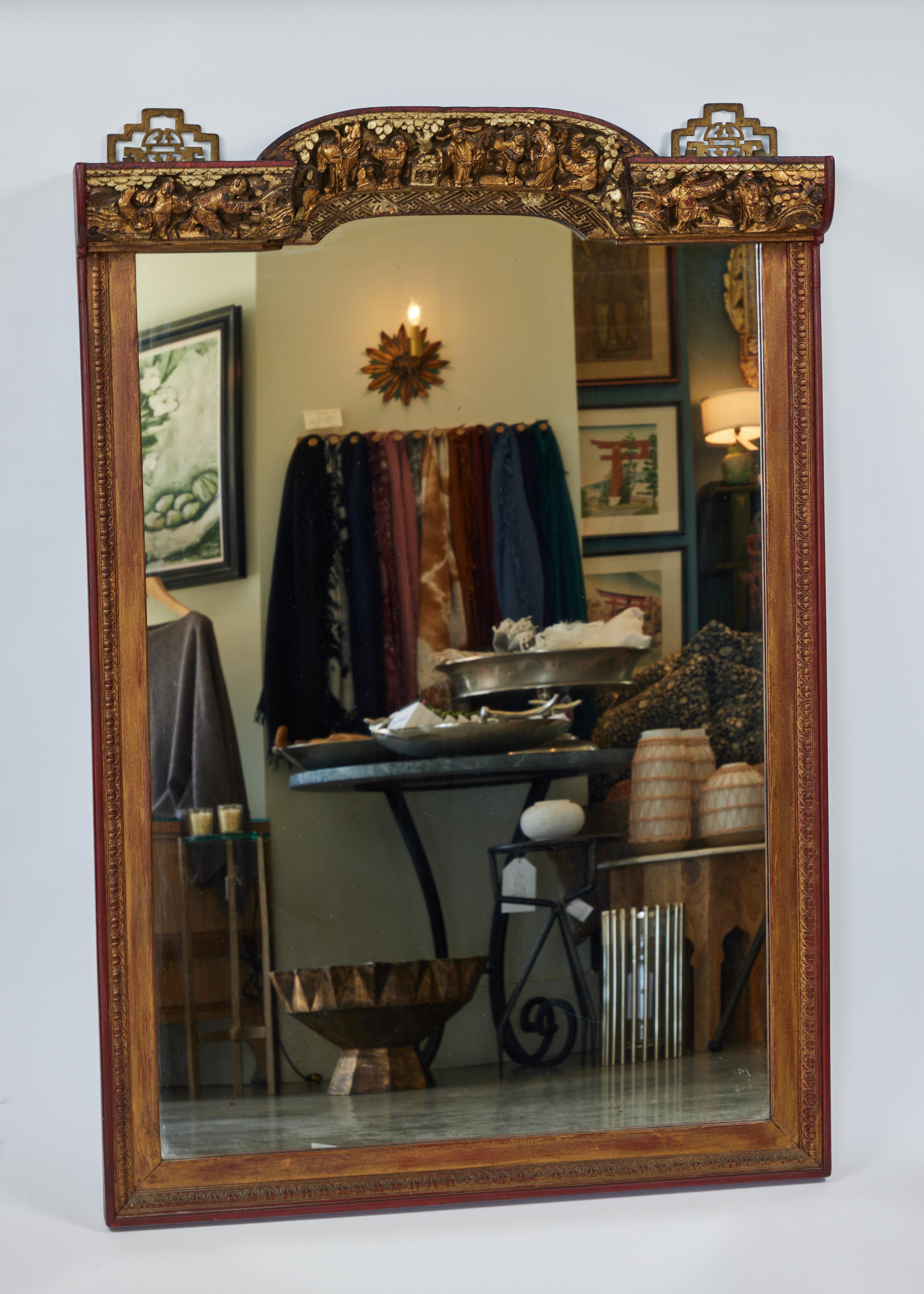 Striking antique rectangular Asian giltwood frame mirror with intricately hand carved detailing on top (depicting village life).