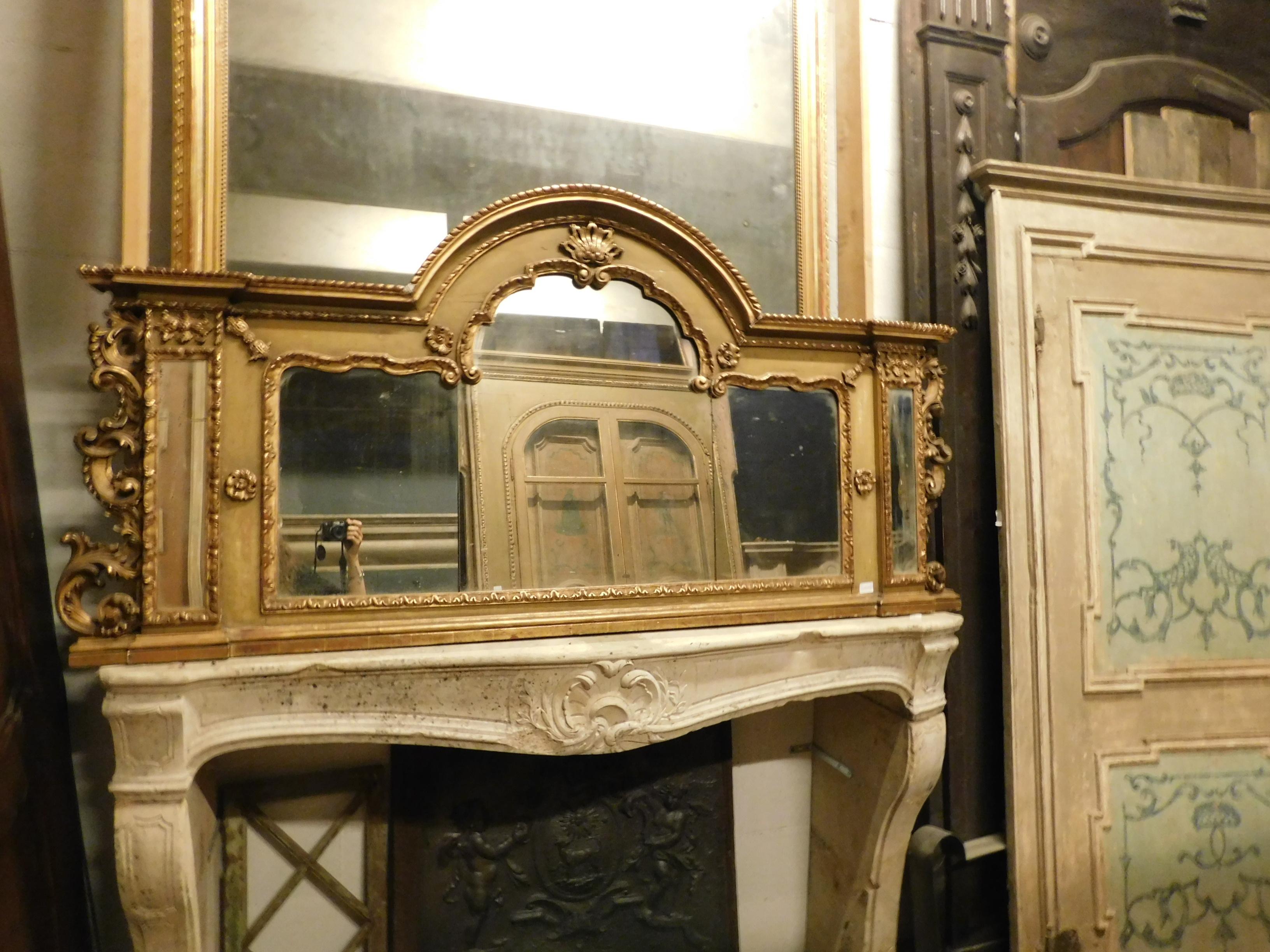 Antiker Holzspiegel, rechteckige Form mit zentralem Bogenteil, reich geschnitzter Holzrahmen, lackiert und vergoldet, Dekoration mit Blumen und Formen der Zeit, handgefertigt im 20. Jahrhundert in Italien.
Ideal in einem Badezimmer, da seine Form,