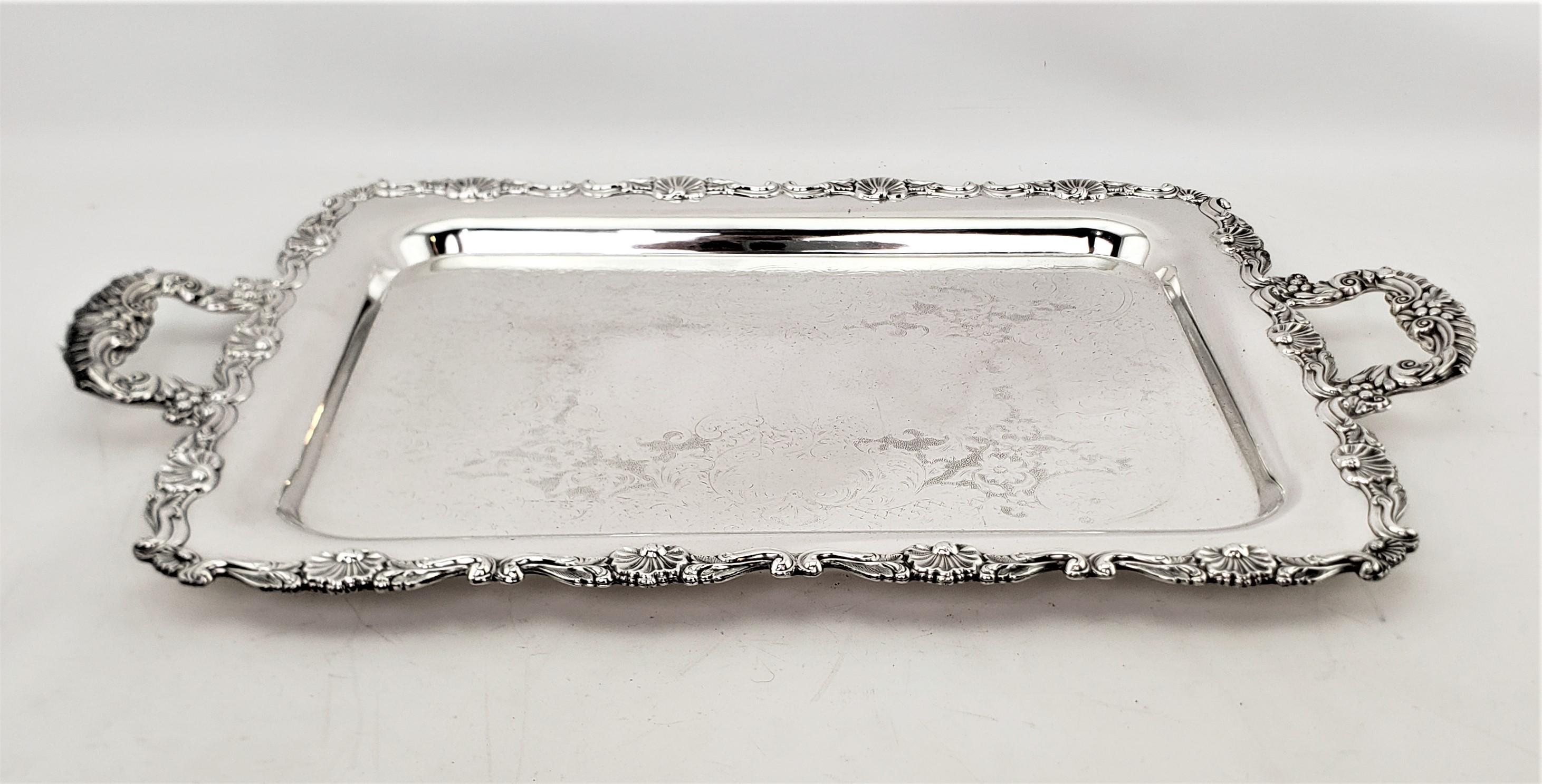 This antique rectangular silver plated serving tray is unsigned, but presumed to have originated from England and date to approximately 1920 and done in a Victorian style. The tray is done with a stylized floral border which is accented by the