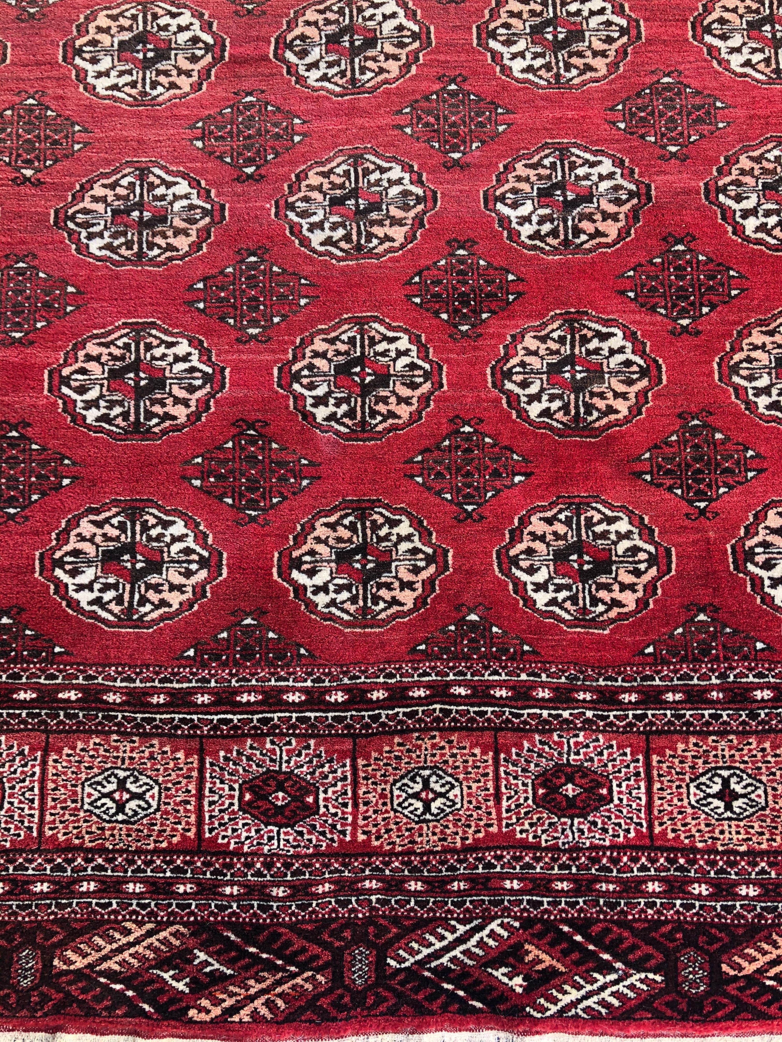 This traditional beautiful rug features a multitude of beautifully angular elements, chosen for their presence with the rich colors and characteristic octagonal Ersari tribal guls. A wonderful palette is present, mixing vivacious reds, creamy whites