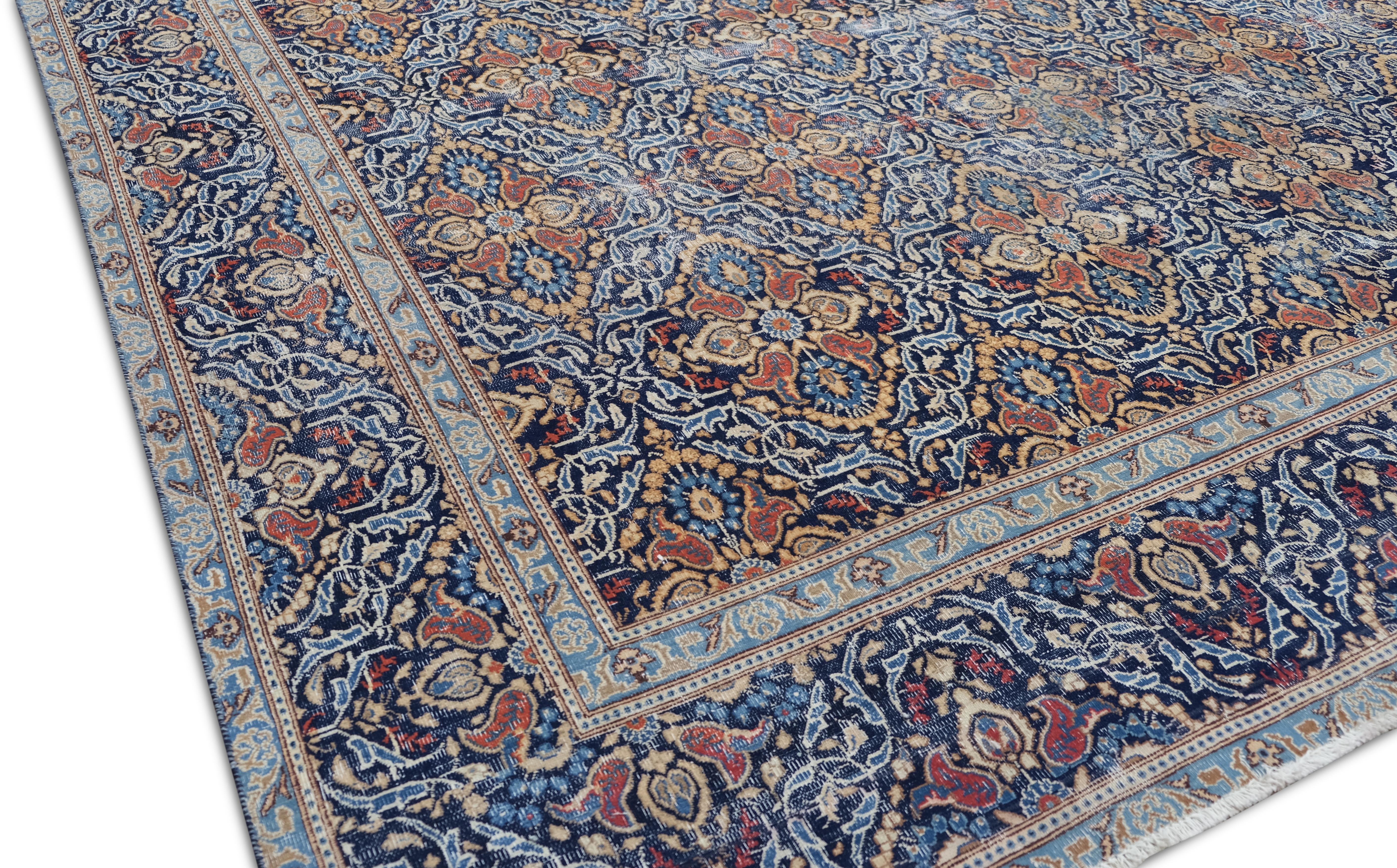 Cet exquis tapis ancien en laine noué à la main présente un fascinant motif floral en treillis, tissé de manière complexe dans des tons bleu profond, ivoire et rouge riche. Les détails artisanaux reflètent les traditions séculaires de fabrication