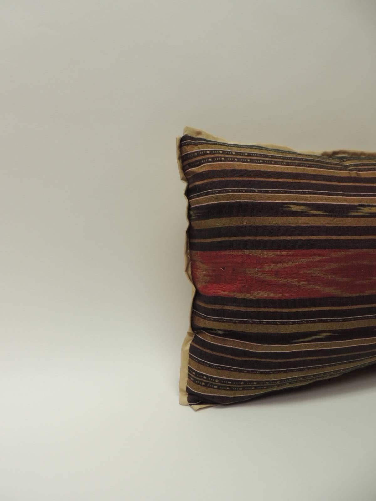 Vintage silk Laos bolster pillow. Traditional tribal pattern in shades of red, gold, brown, yellow and purple.
Embellished with the ATG custom gold flat silk trim same as backing.
Decorative pillow handcrafted and designed in the USA. 
Closure by
