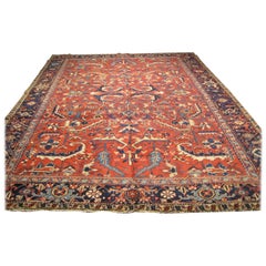 Ancien tapis persan Heriz à bordure géométrique rouge, or et bleu marine, avec motif tribal, vers les années 1930