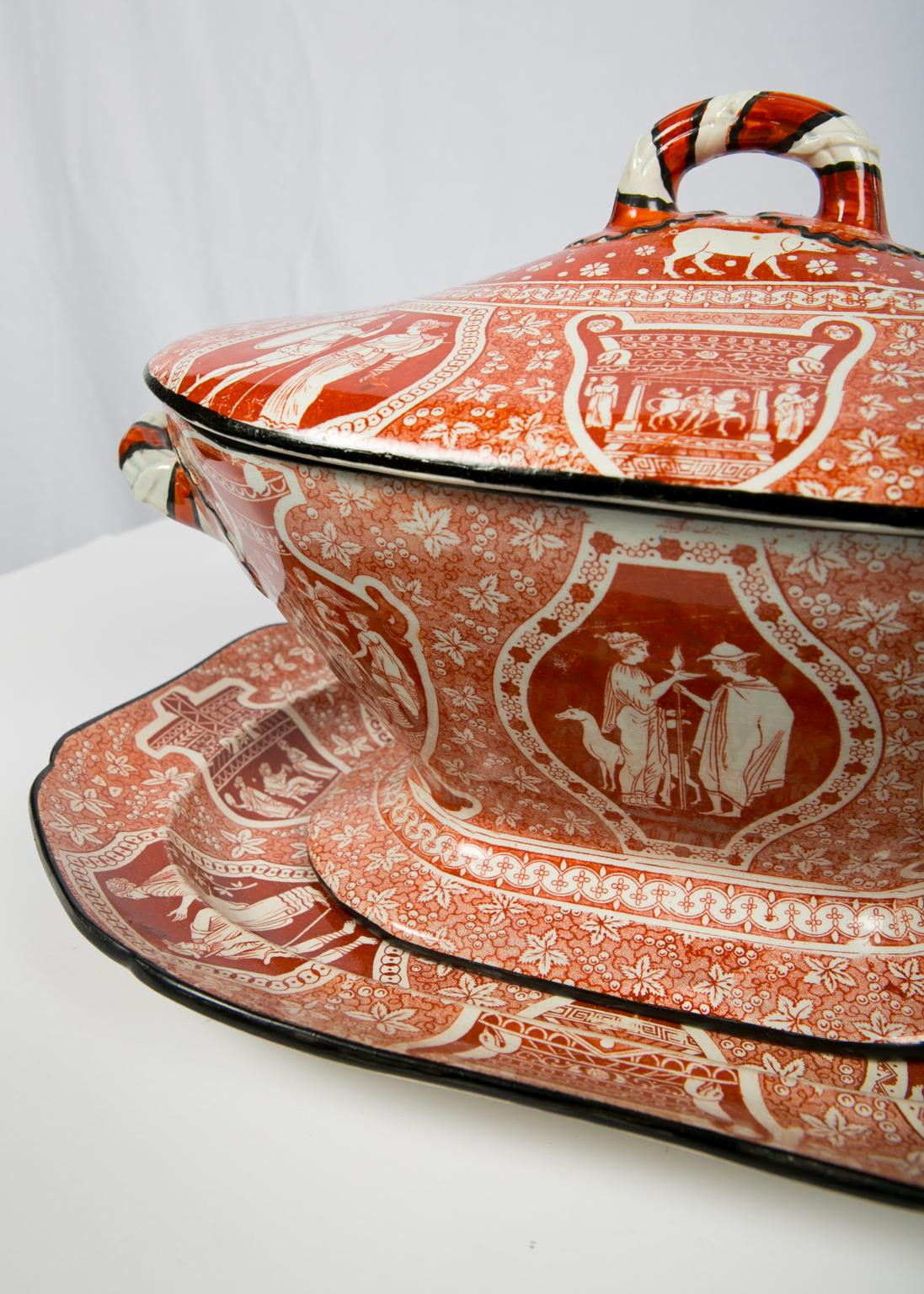 WHY WE LOVE IT: If anyone has more of this please call.
We are pleased to offer this antique red Greek ware soup tureen decorated with classical figures. The color is just glorious, and we are thrilled to be offering this tureen. In the 57 years