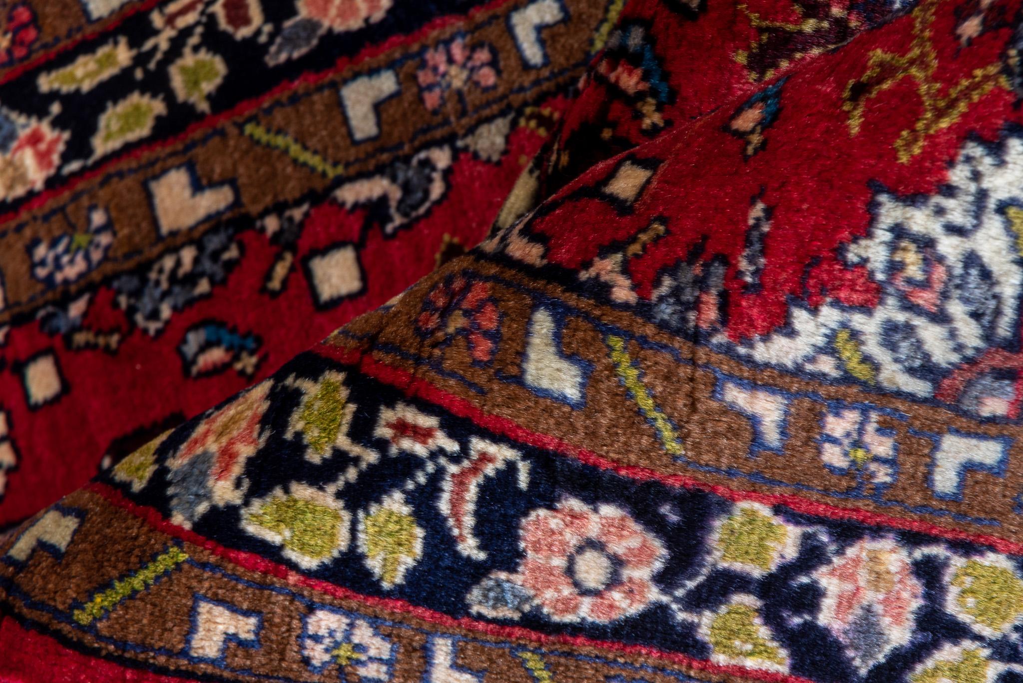 Es misst 2,4 x 4,0 Fuß und bietet ein klassisches Design mit einem leuchtend roten Feld, komplizierten Blumenmustern und einer detaillierten Umrandung. Die handgewebte Kunstfertigkeit des Teppichs spiegelt seine Herkunft und Tradition wider und