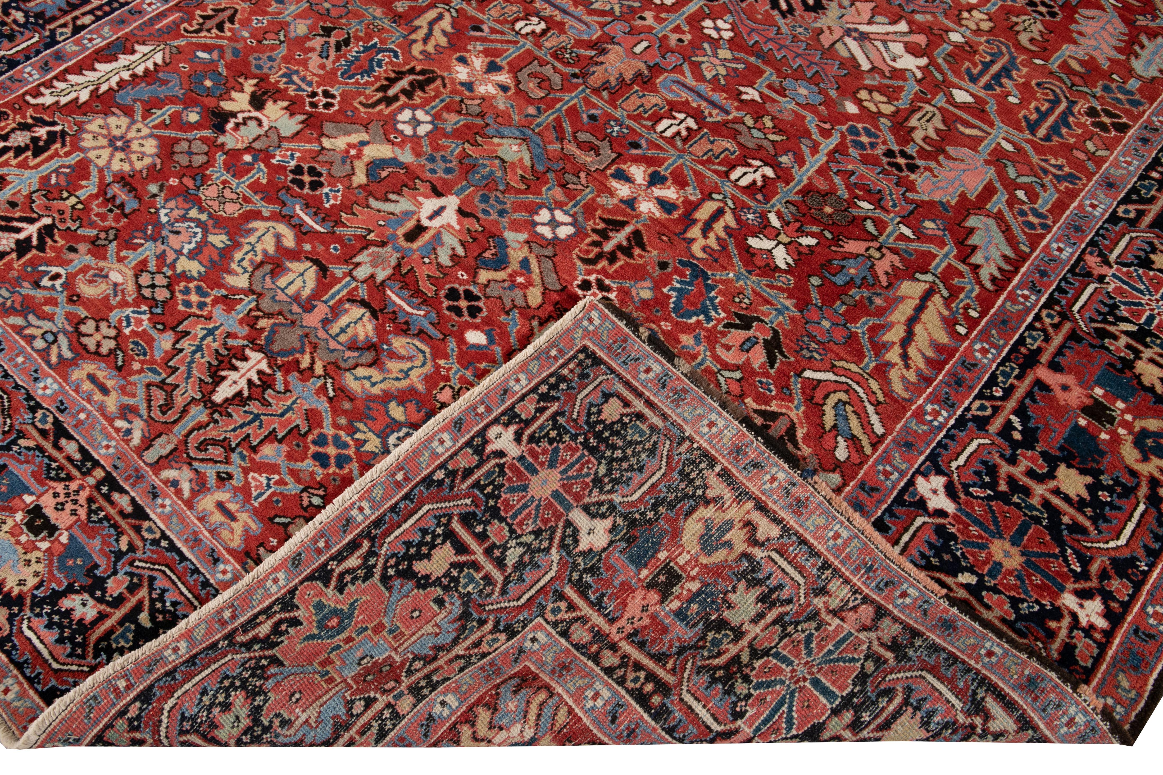 Beautiful antique Persian distressed Heriz hand knotted wool rug with a red field. This Heriz rug has multi-color accents in an all-over gorgeous geometric floral design.

This rug measures: 8'1