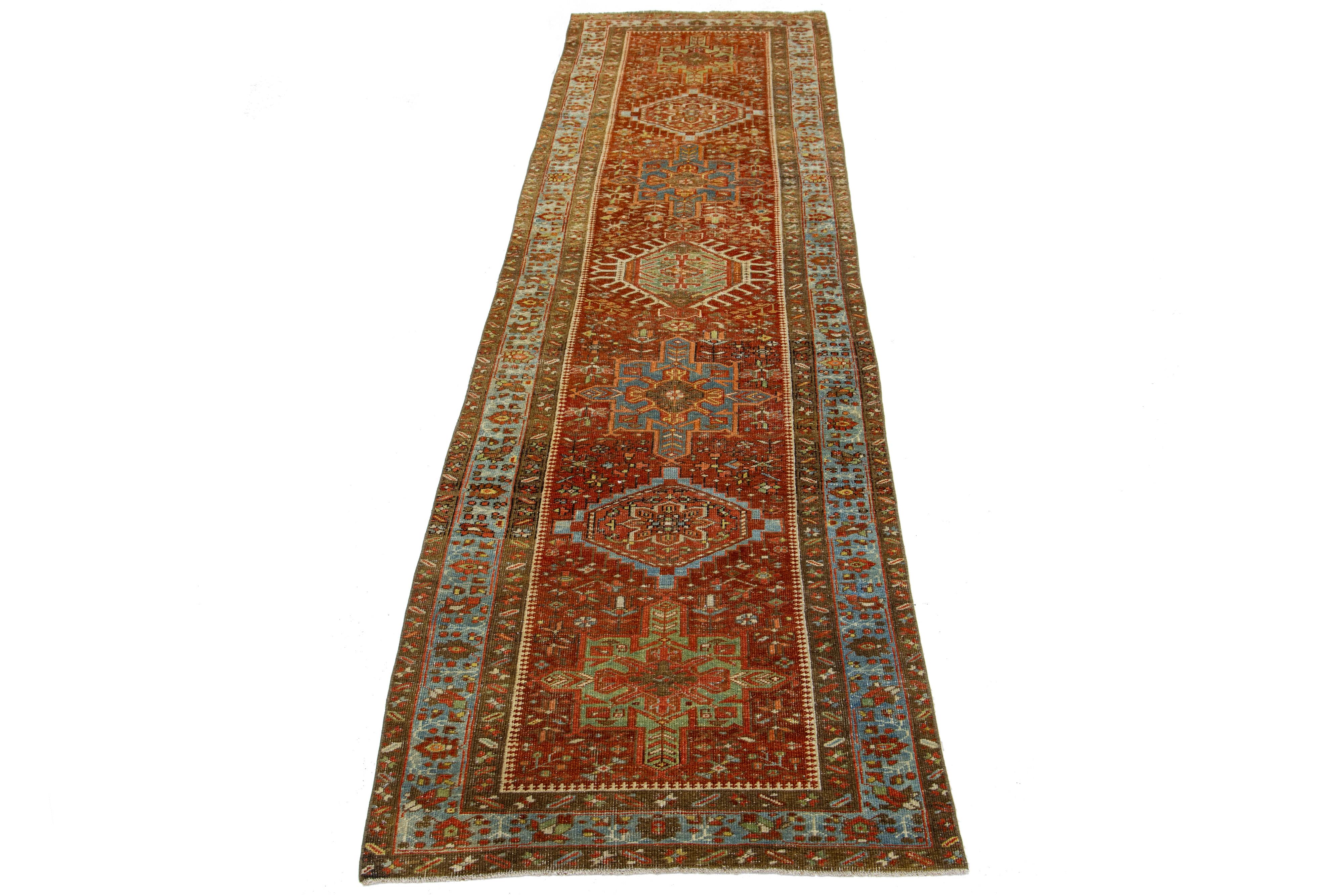 Beautiful 20th-century Heriz hand-knotted wool runner with a red-rust color field. This Piece has multicolor accents in a gorgeous tribal design.

This rug measures 3' x 11'3