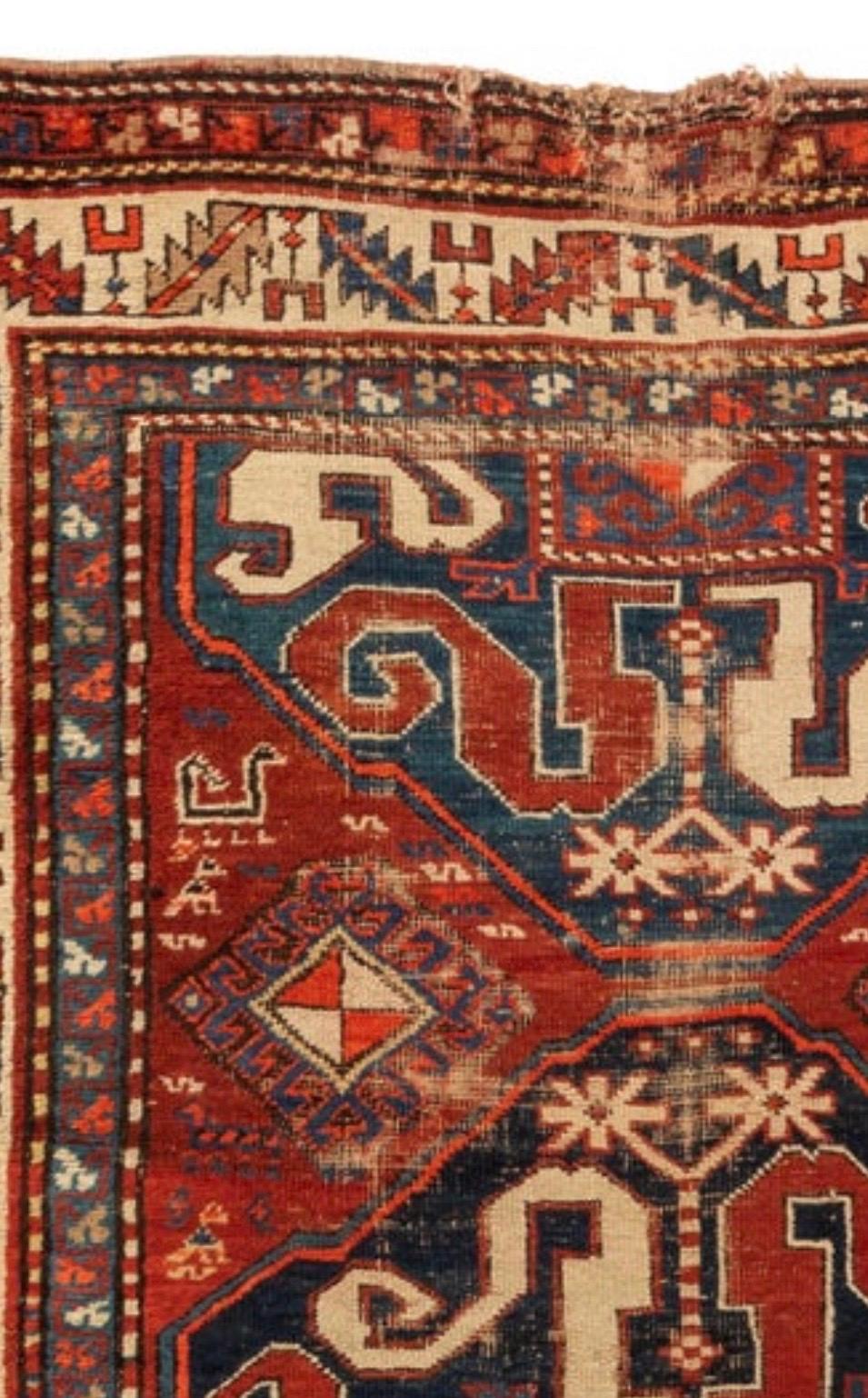 This is a well-worn hand knotted antique red ivory and navy blue distressed tribal Caucasian Kazak rug circa 1880s measuring 4.3 x 7.7 ft.

 