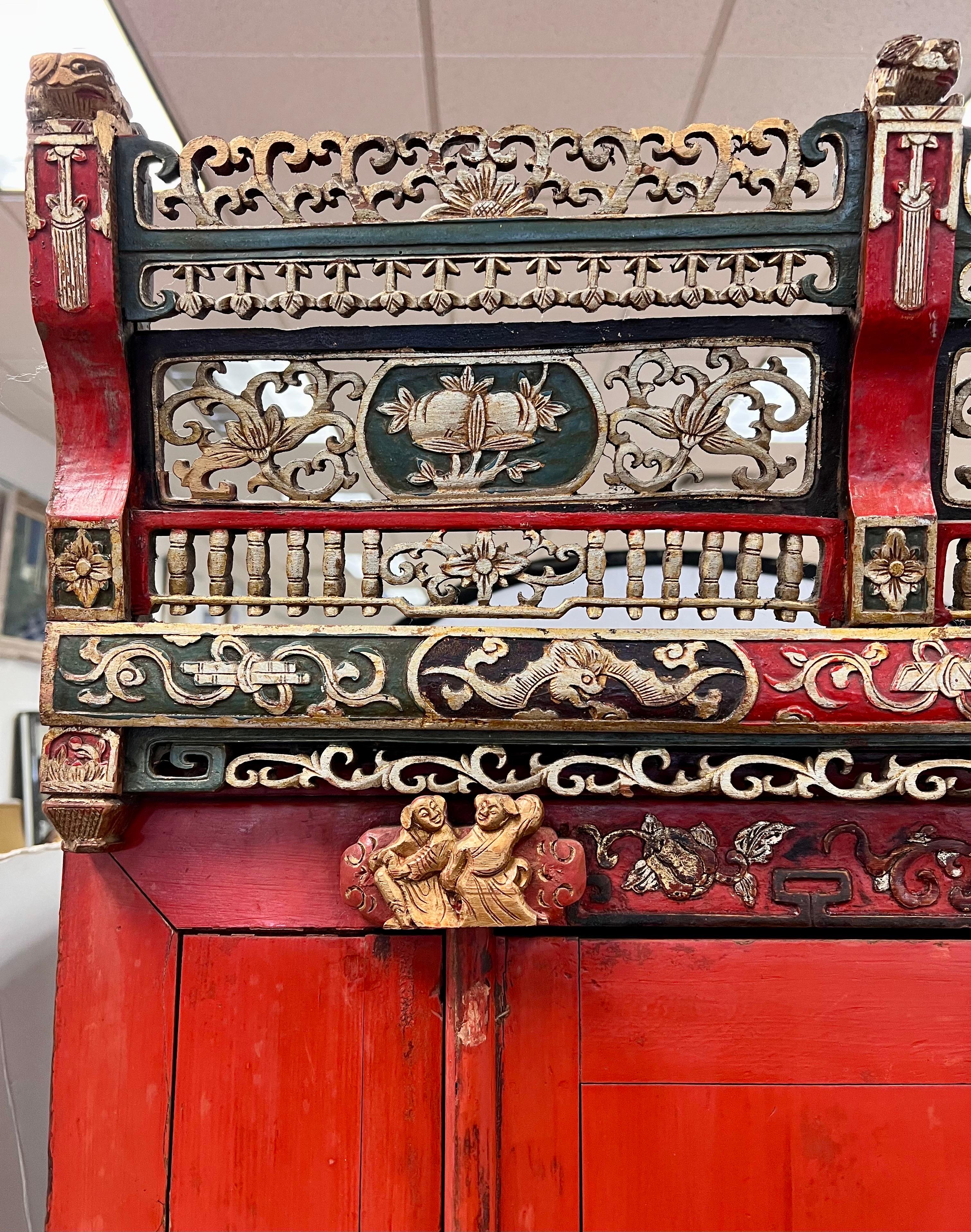An extraordinary Chinese red lacquered Wedding Cabinet with a stunning, intricately carved original crown. 