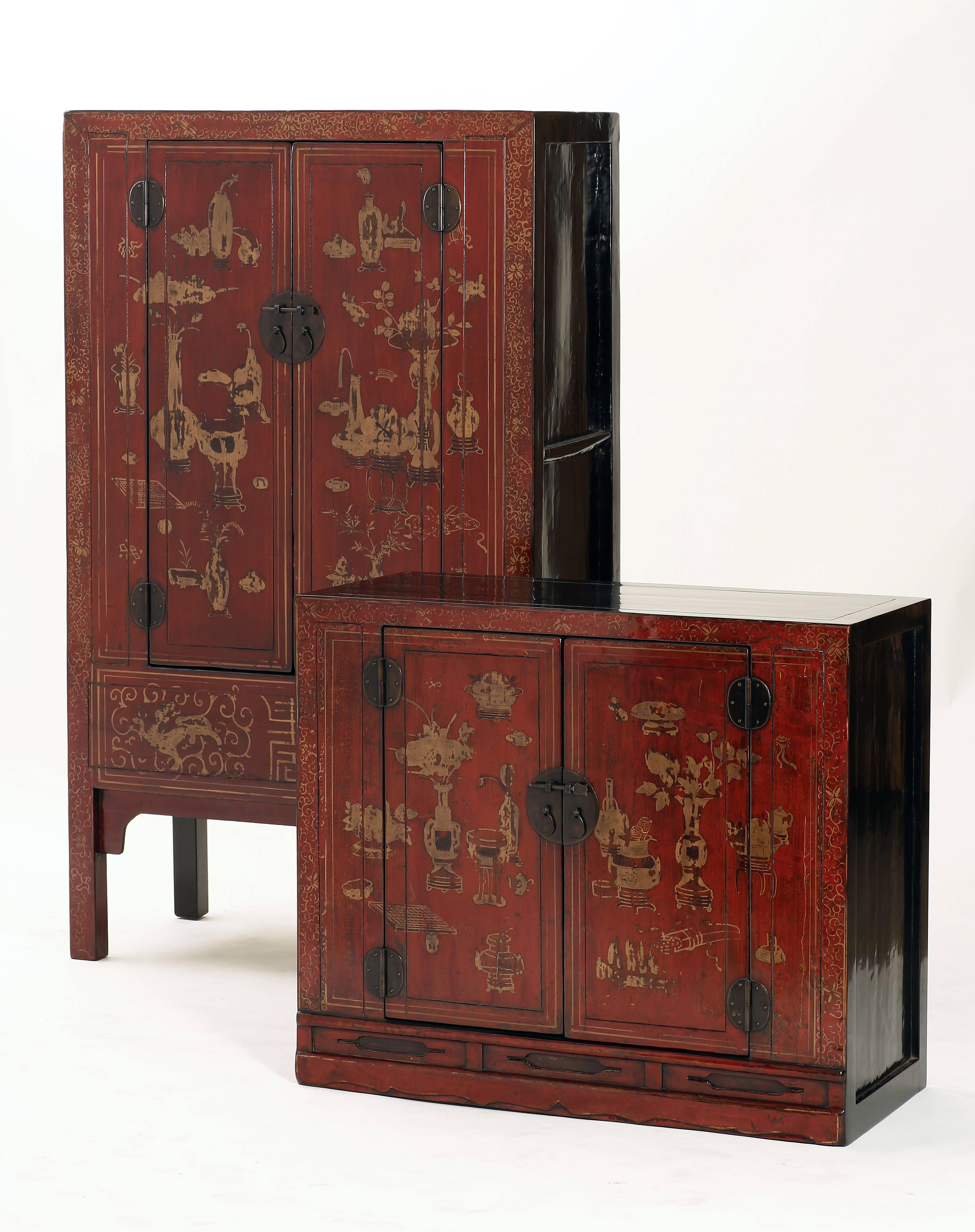 Of rectangular form, the cabinet consisting of two sections, the top section in the form of a book chest and the lower section square corner cabinet, each section with a pair of door panels hand painted with flowers in vases and scholastic treasures