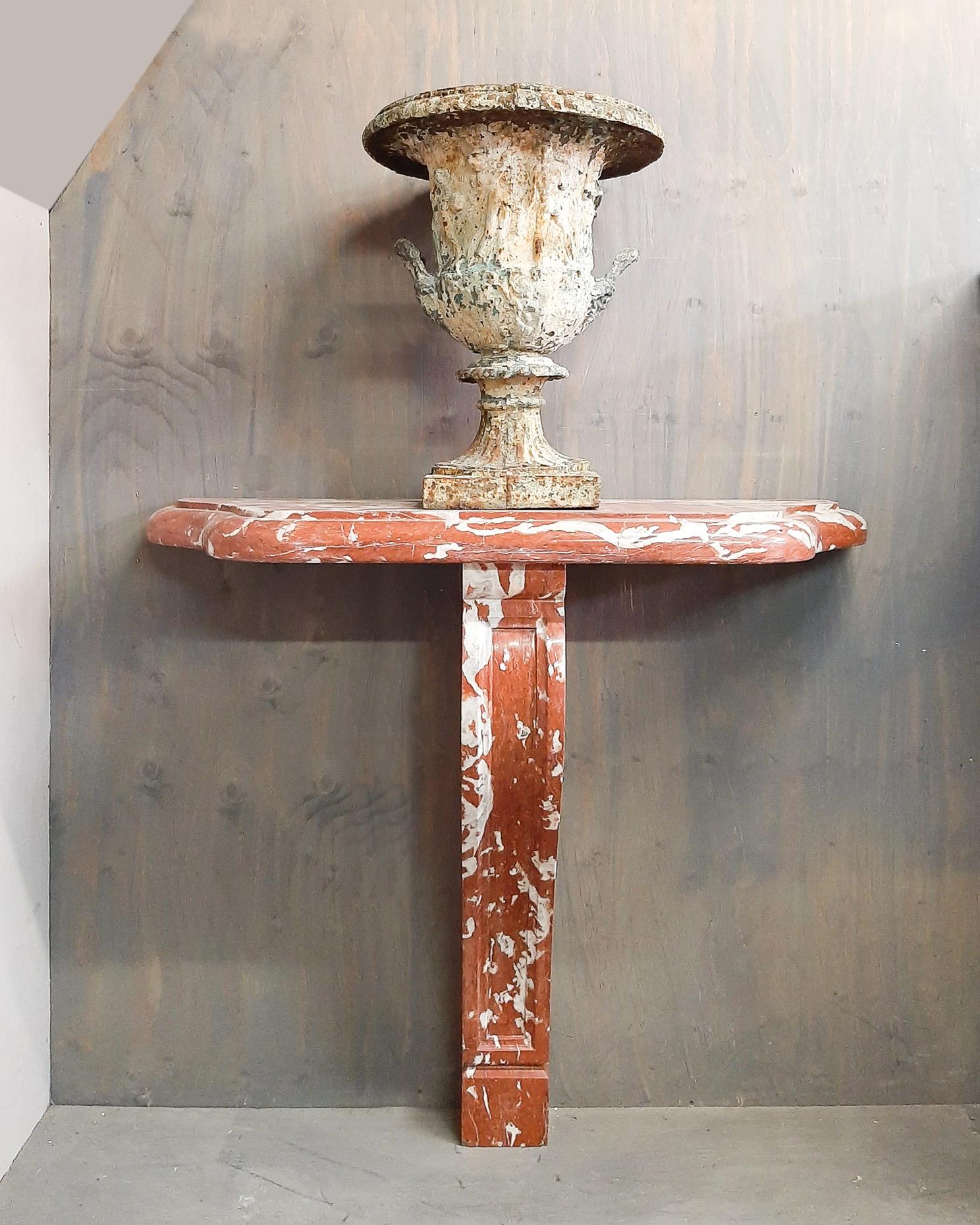 Antique red marble console table. This stylish console is made of Rouge de Languedoc marble.

Console dimensions: H 92 x W 102 x D 35 cm

Shown here with a 19th century cast iron vase with mythological images. This combination of the red marble