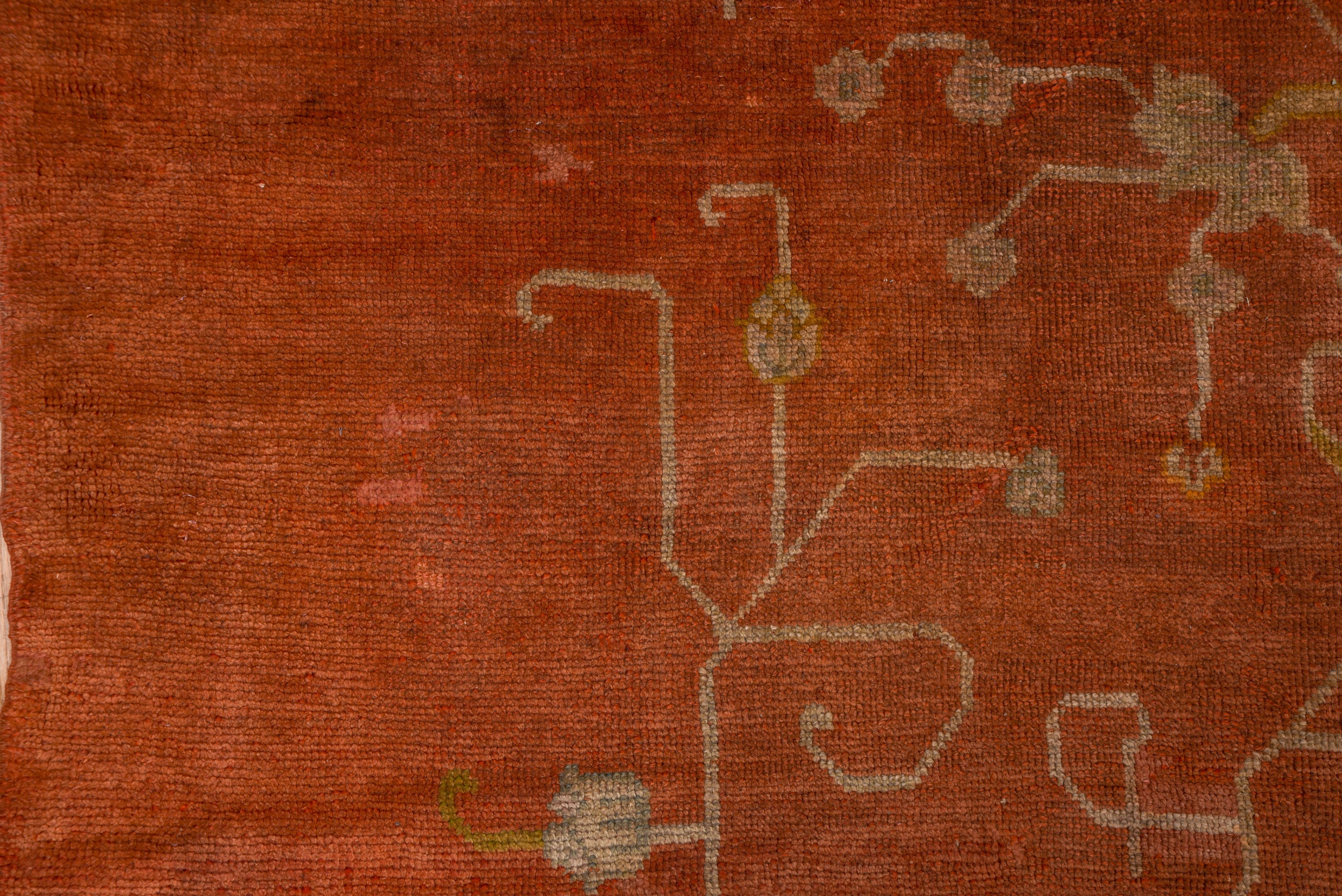 Ce grand tapis d'atelier rouge dinde d'Anatolie occidentale présente un arrangement ouvert de tiges, de feuilles, d'acanthes fendues et de palmettes, le tout centré autour d'une composition à double vase, détaillée en sarcelle, rouille et vert.