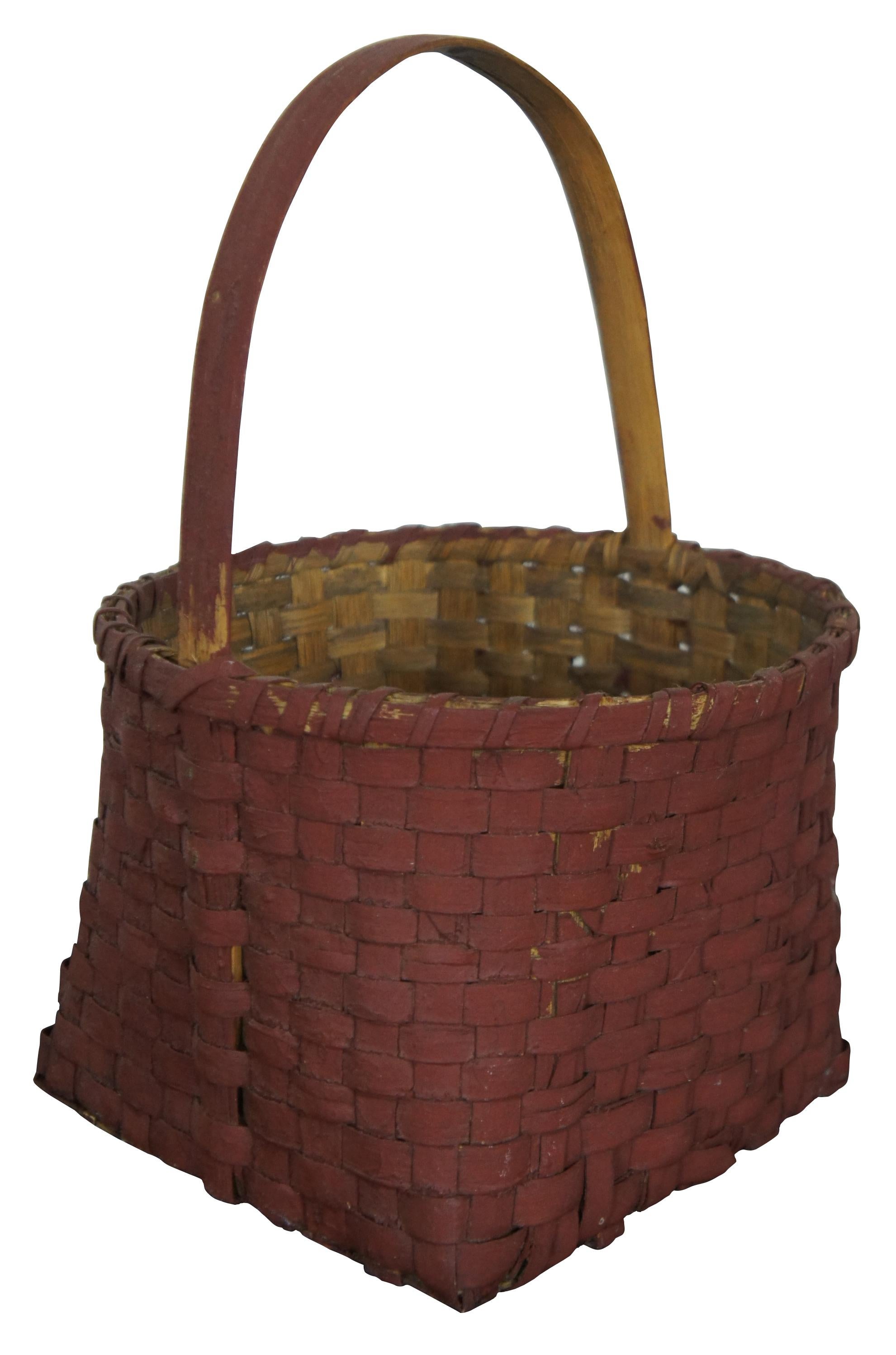 Vintage red painted woven folk art basket with square base, rounded sides, and fixed handle. Measure: 13''.
 