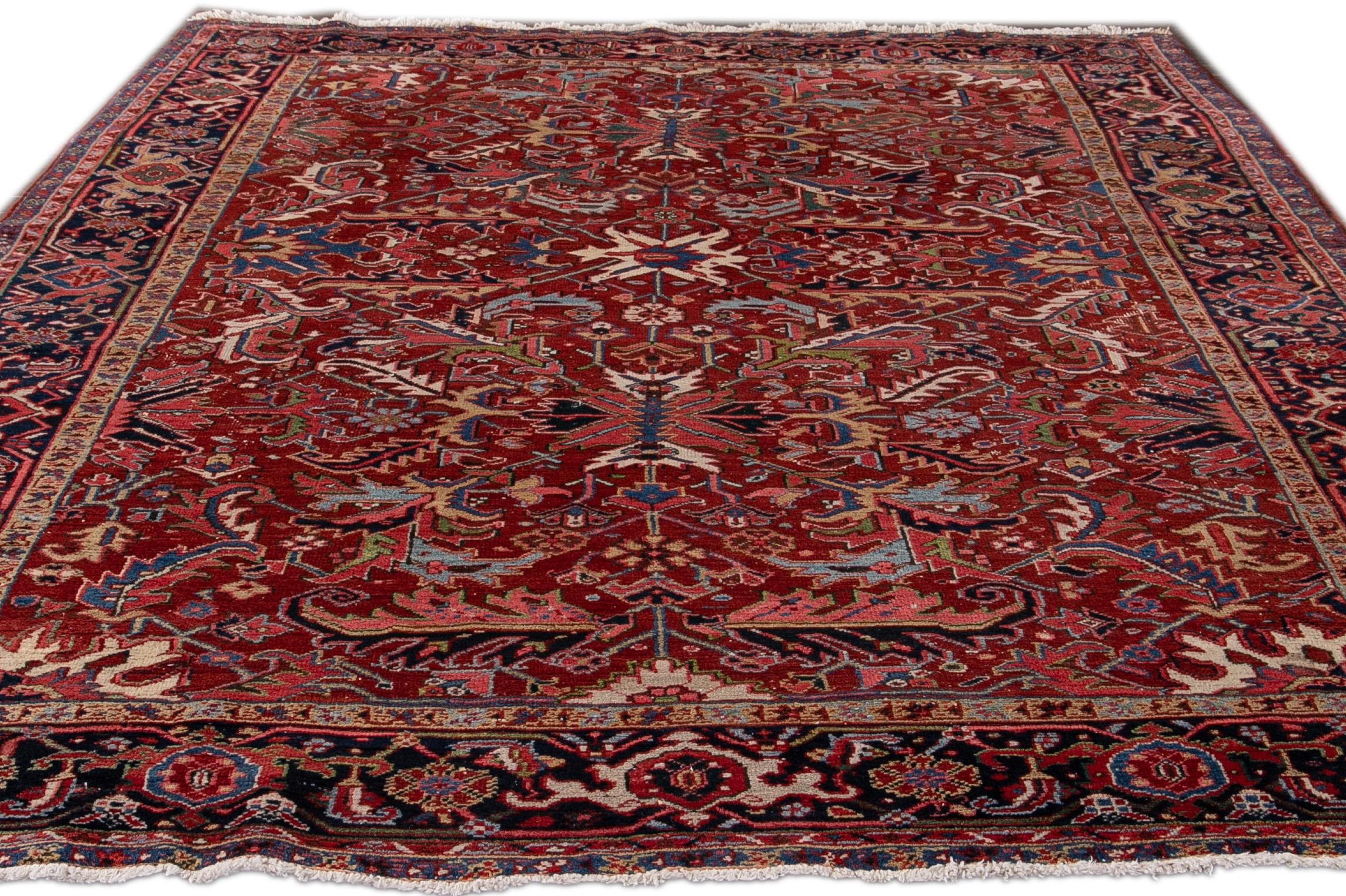 Beautiful antique Persian Heriz hand-knotted wool rug with a red field. This Serapi rug has a navy-blue frame and multi-color accents in an all-over gorgeous geometric medallion floral design.

This rug measures: 8' x 10'1