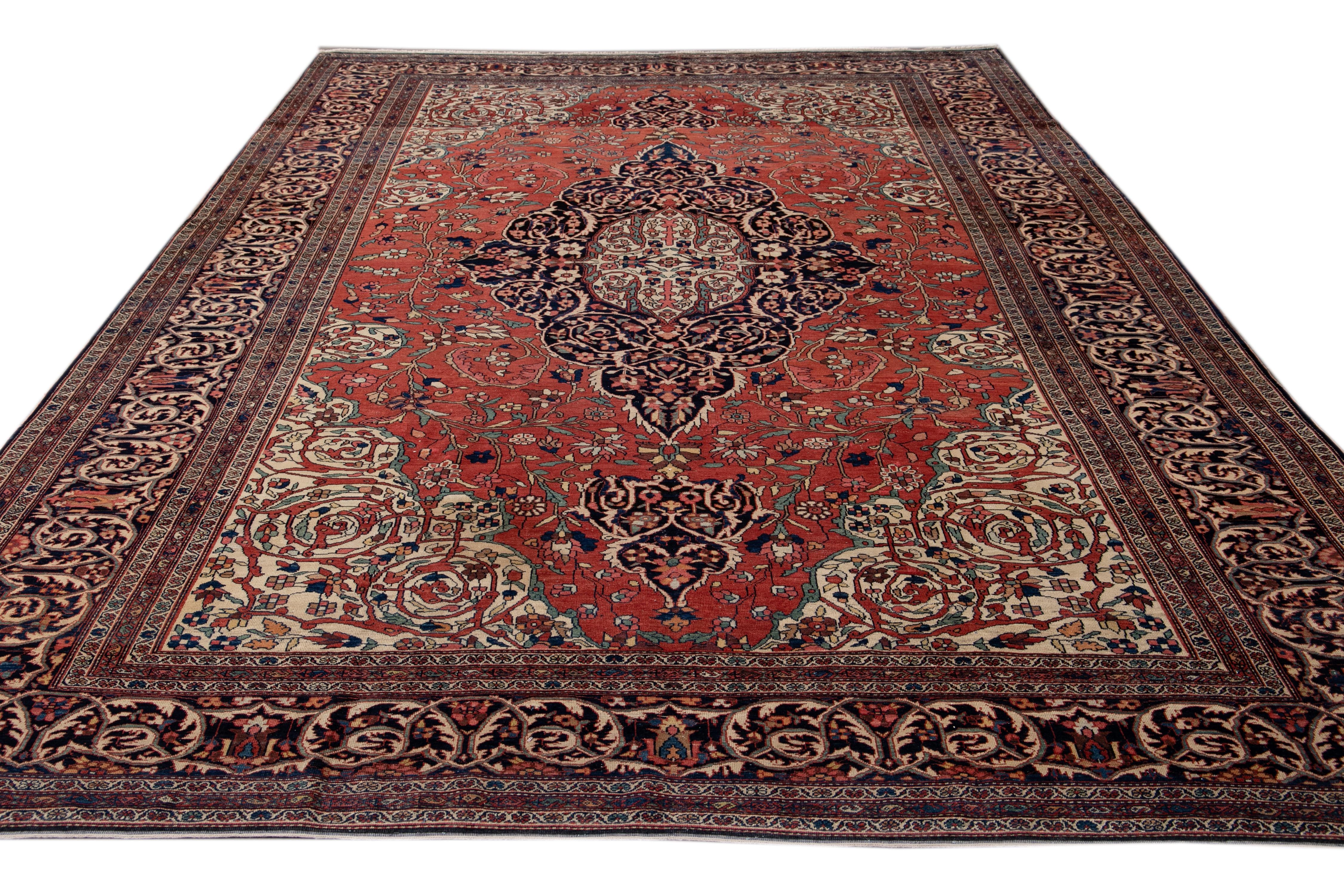 Beautiful antique Farahan hand-knotted wool rug with a red field. This Persian rug has multi-color accents on a Classic floral medallion design.

This rug measures 8'9