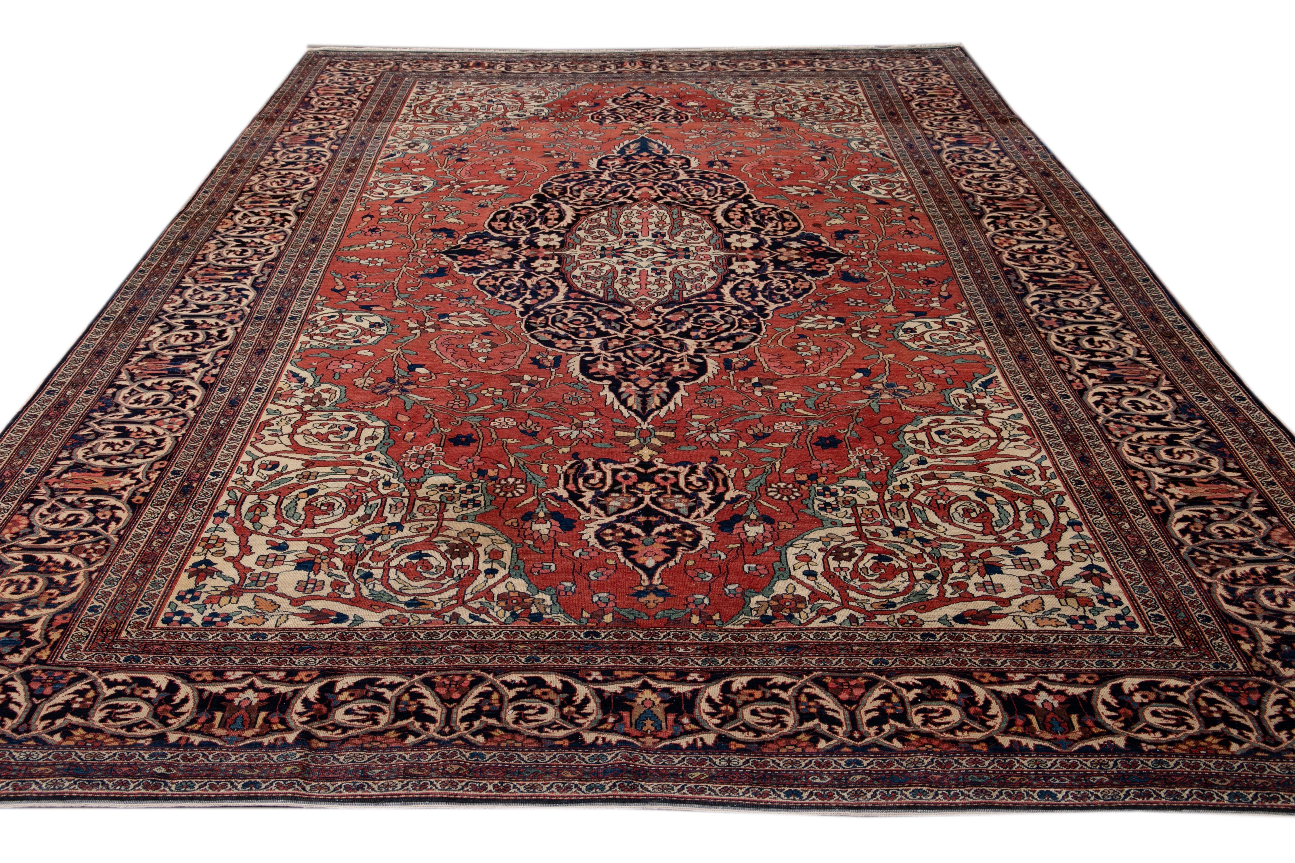 Magnifique tapis ancien de Farahan en laine nouée à la main avec un champ rouge. Ce tapis persan présente des accents multicolores sur un motif de médaillon floral classique.

Ce tapis mesure 8'9