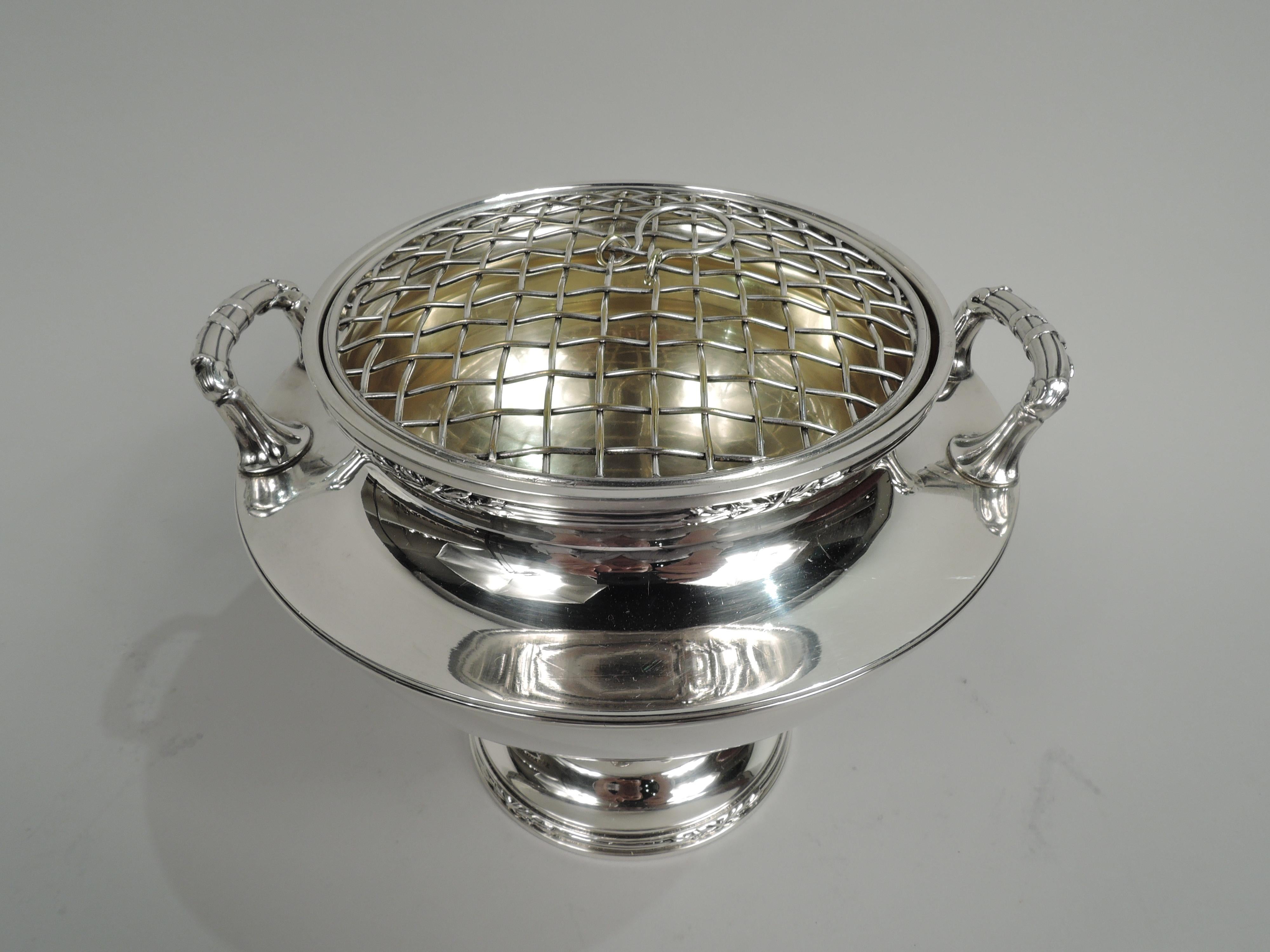 Edwardian Classical sterling silver vase. Made by Reed & Barton in Taunton, Mass. ca 1915. Round and tapering bowl with bracket side handles mounted to flat shoulder, and short and inset neck; raised and fluted foot. Reeding. Gilt-washed interior.