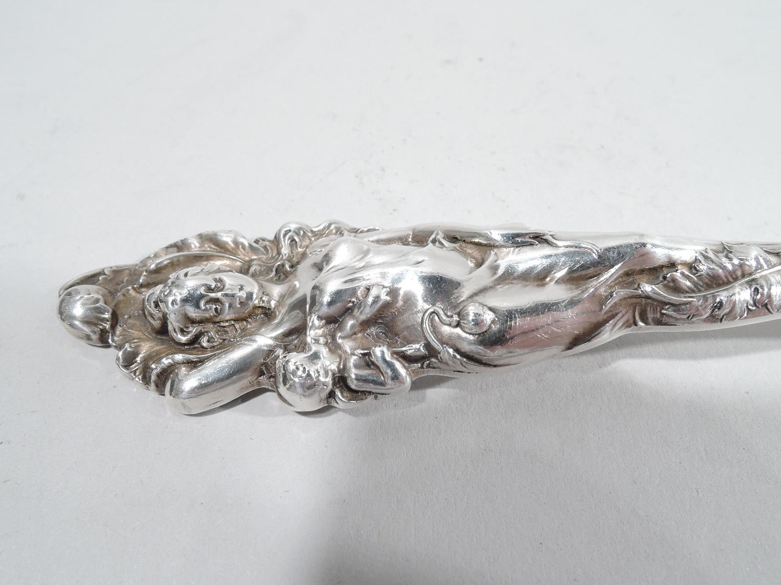 Love disarmed sterling silver tomato server. Made by Reed & Barton in Taunton, Mass, ca 1920. Round shaped blade with ornamental piercing. Handle in form of voluptuous maiden in clingy drapery with Cupid peeking out from behind. A nice piece in the