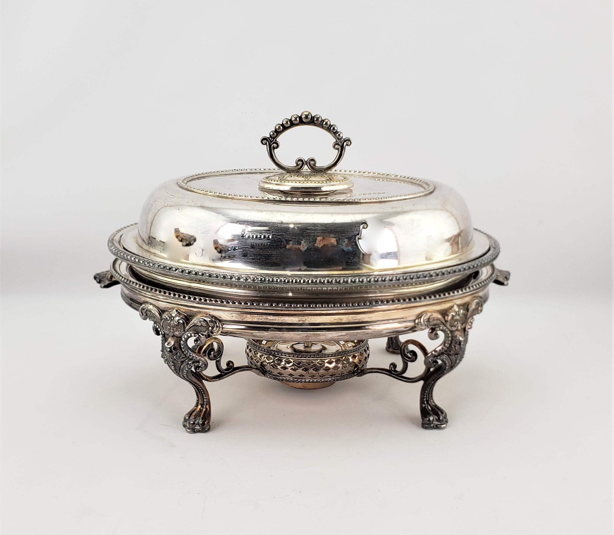 This antique silver plated warm food server was made by the well known Reed & Barton of the United States in approximately 1920 in an Edwardian style. The oval server or chafing dish has a graduated lid with stylized rope borders which are accented