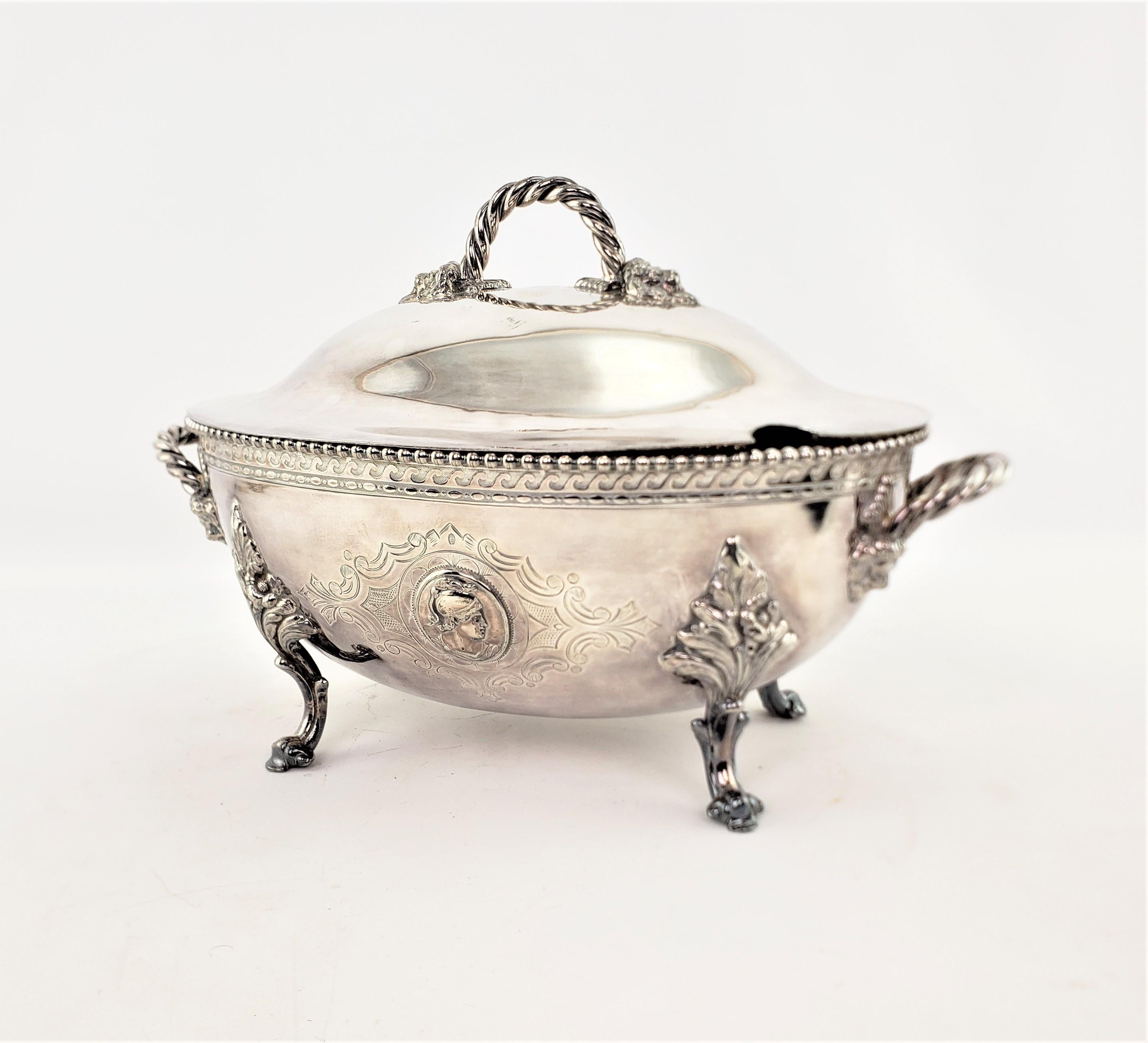 This antique tureen was made by the well known Reed & Barton Company of England and dates to approximately 1880 and done in the period Victorian style. This large egg shaped tureen is made of silver plate with stylized rope handles and lion head