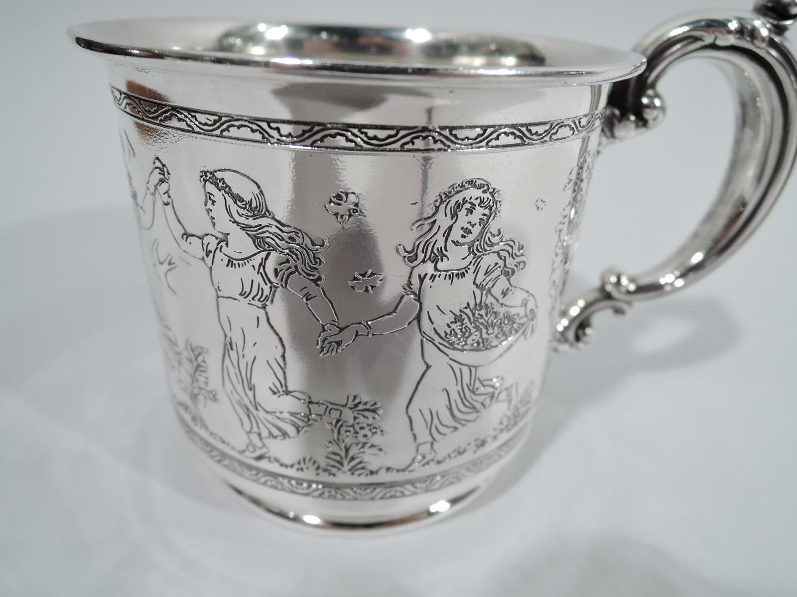 Edwardian Art Nouveau sterling silver baby cup. Made by Reed & Barton in Taunton, Mass., circa 1910. Straight sides and short inset foot; leaf-capped double-scroll handle. Acid-etched frieze depicting Botticelli-inspired nymphs holding hands and