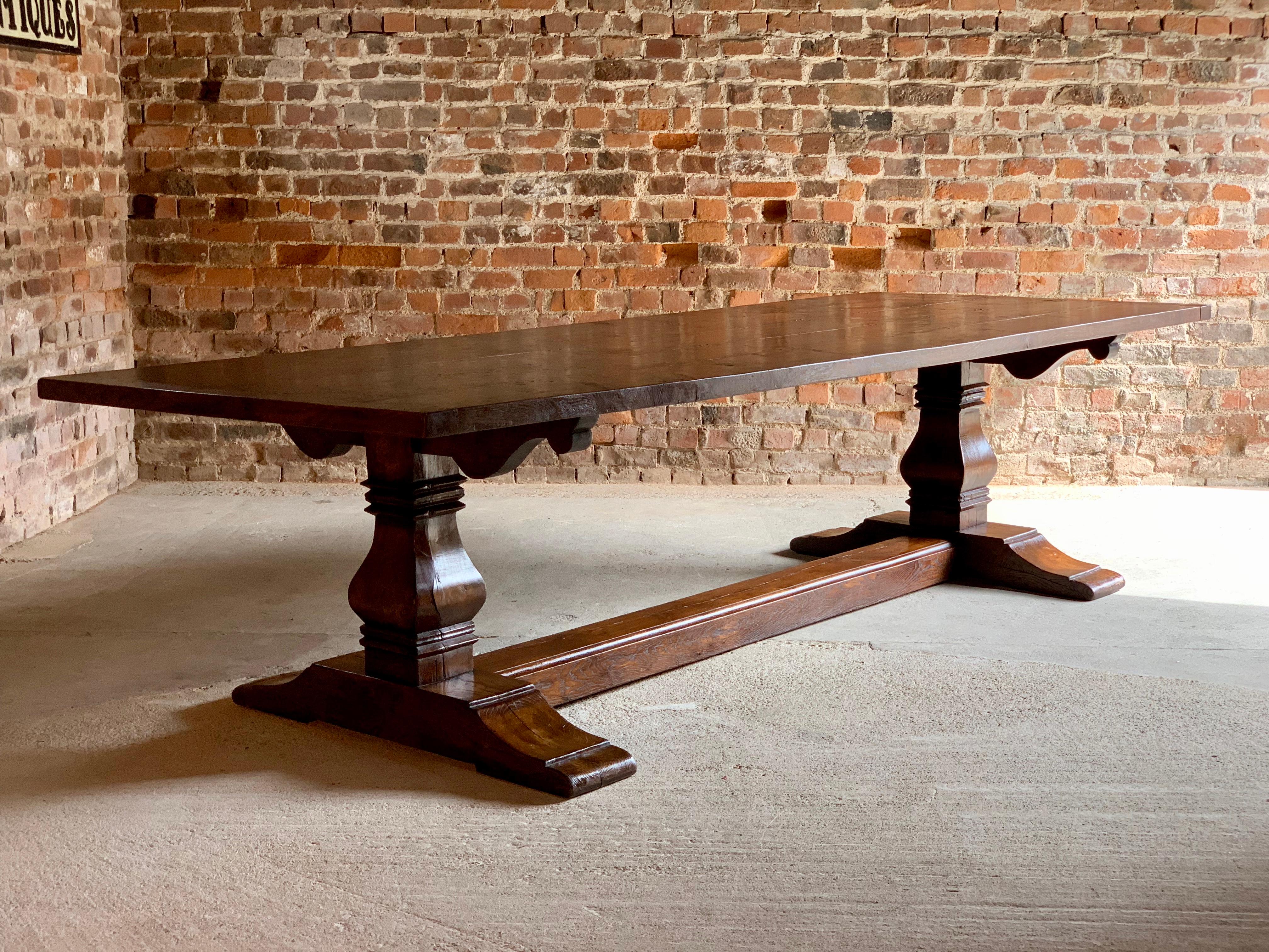 A magnificent top quality Bylaws 17th century style solid oak refectory dining table of large proportions seating 10 people comfortably, circa late 20th century, the solid rectangular planked top rests on a twin bulbous baluster base joined by a