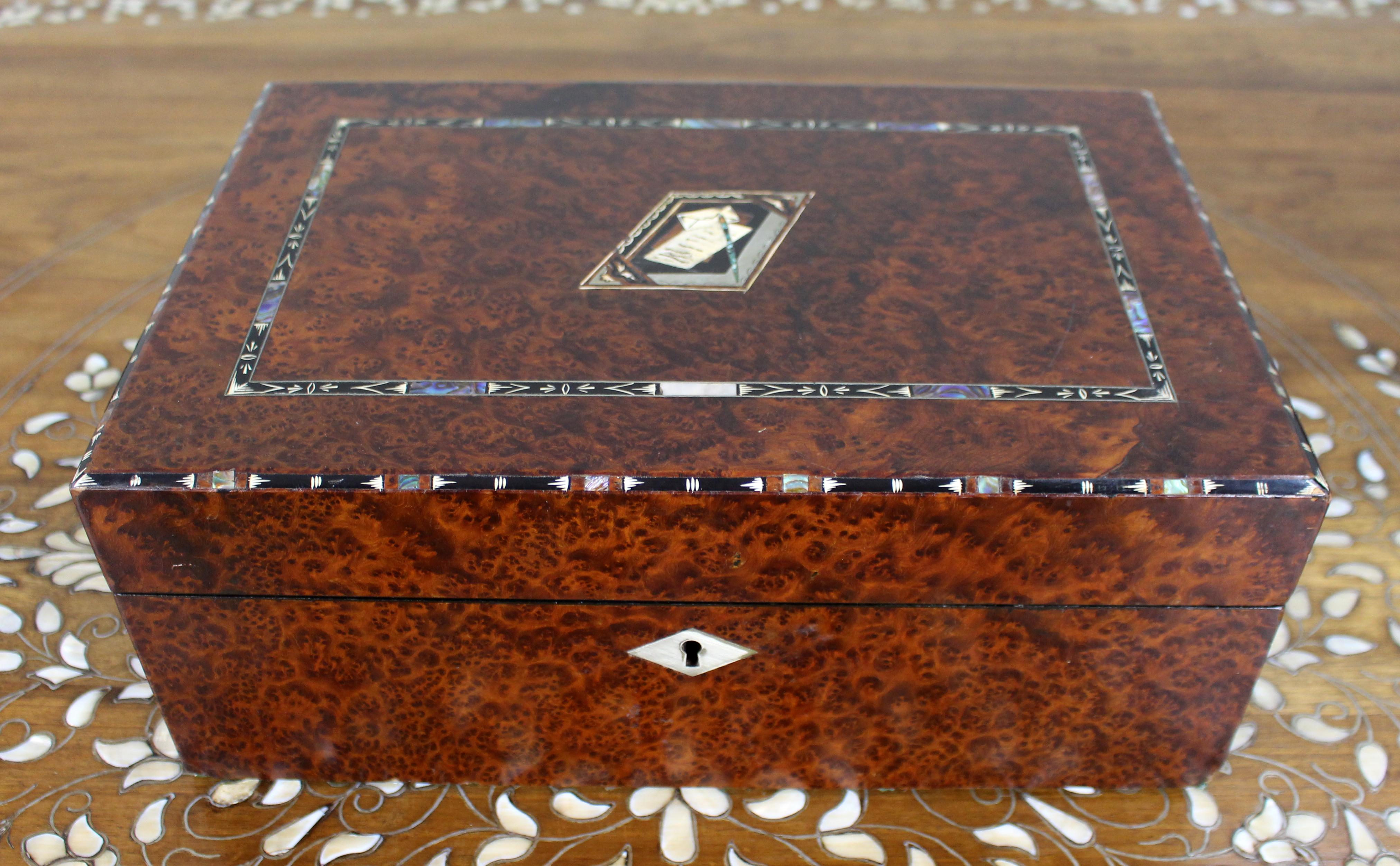 Antique Regency Amboyna & Mother-of-Pearl Inlaid Writing Slope, c.1830

A fine early 19th-century writing slope, veneered in richly figured amboyna burr and decorated with inlay of abalone, mother-of-pearl, ebony, and silver stringing. The lid is