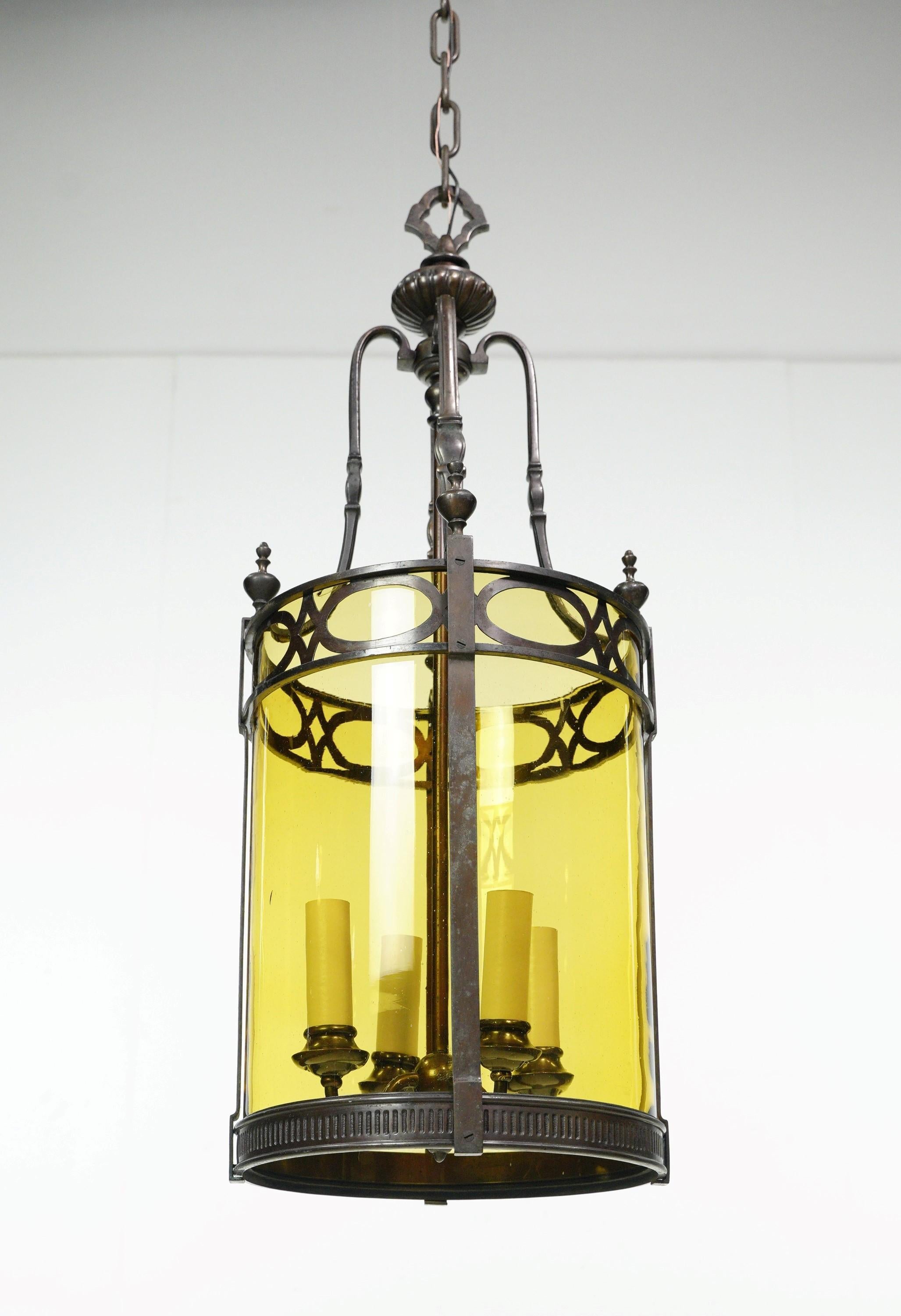 Antique Regency ceiling lantern made of bronze and adorned with amber glass panels. This is a stunning piece that adds vintage charm and warm illumination to any interior with its elegant design. This has four standard medium base sockets. It is in