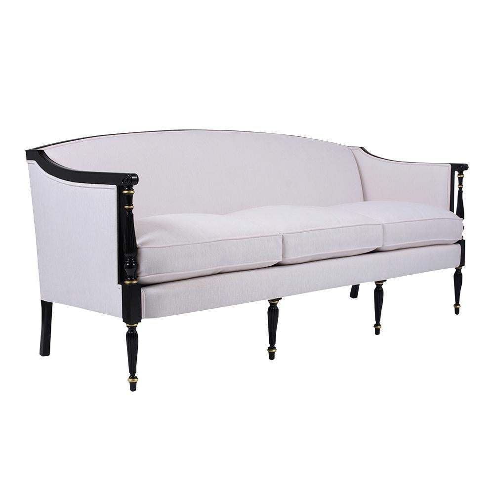 This antique Regency style sofa has been completely restored, is made out of mahogany wood and has a sleek frame design. The sofa has also been newly refinished in an ebonized color with gilt accents and a newly lacquered finish. This sofa features