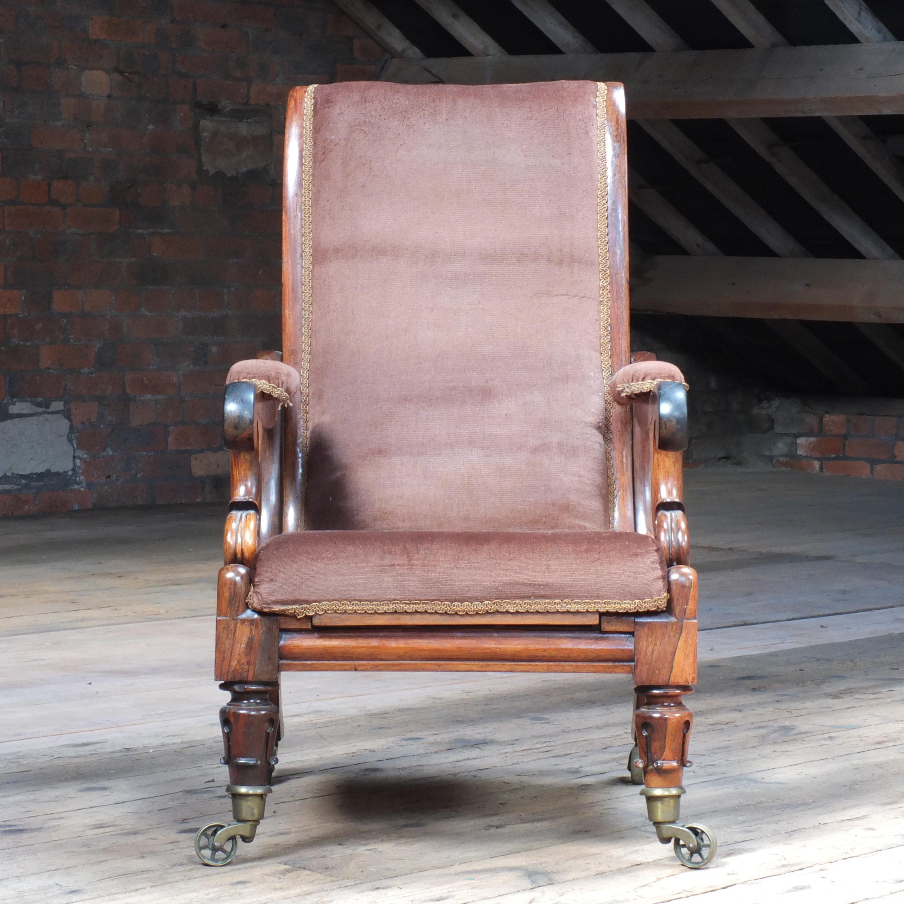 An exquisite William IV reclining rosewood library Armchair in the manner of R. Dawes. Sitting on the finest quality large spoked brass castors by Lewty. Showing signs of a few old repairs and in need of upholstery but structurally sound and very