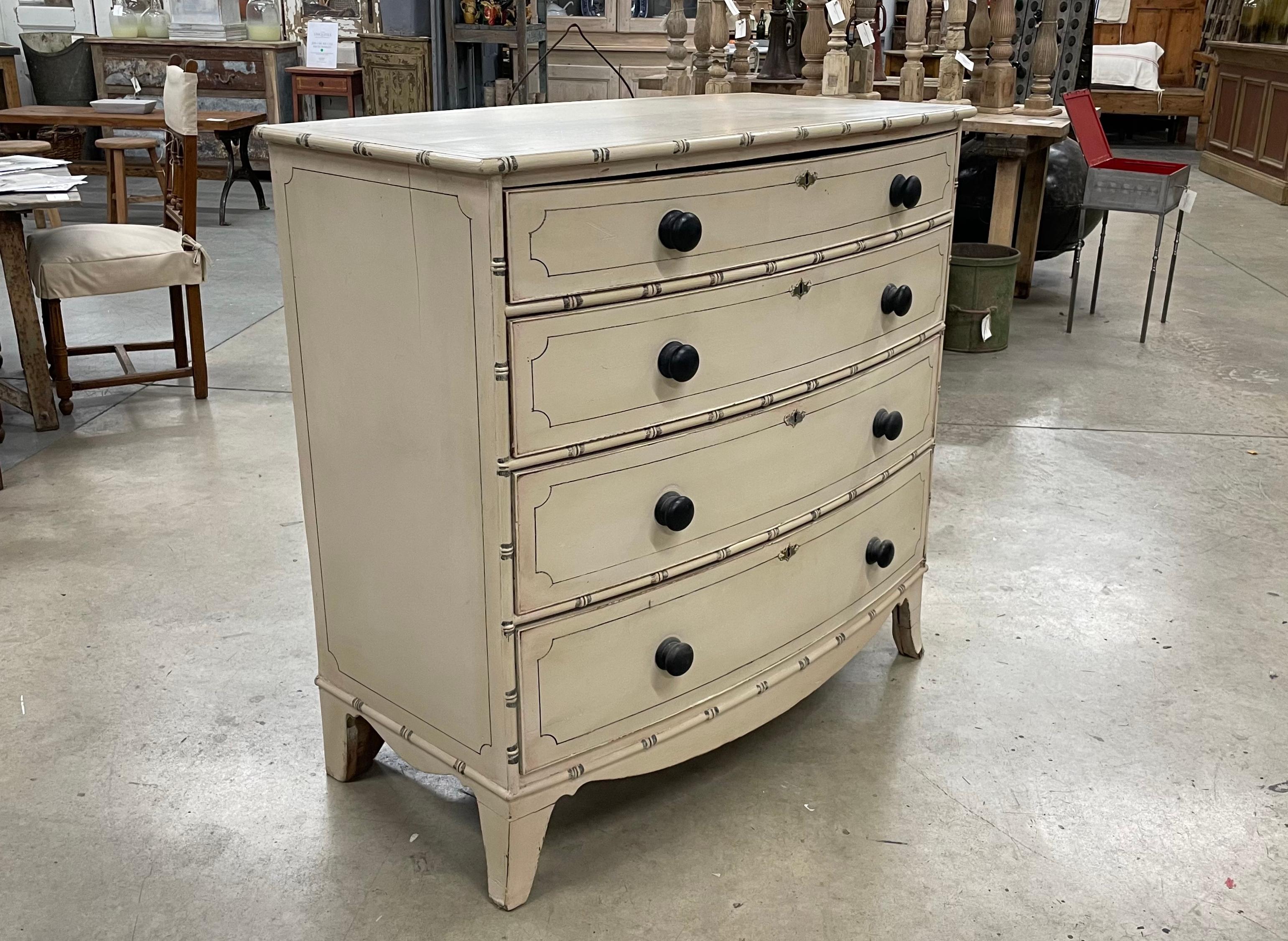 Antique English Regency bow fronted chest of drawers.

This beautiful painted faux bamboo dresser has 2 smaller drawers over 3 larger drawers with original wooden knobs and sits on stile feet.

A versatile piece of furniture that does not have to be