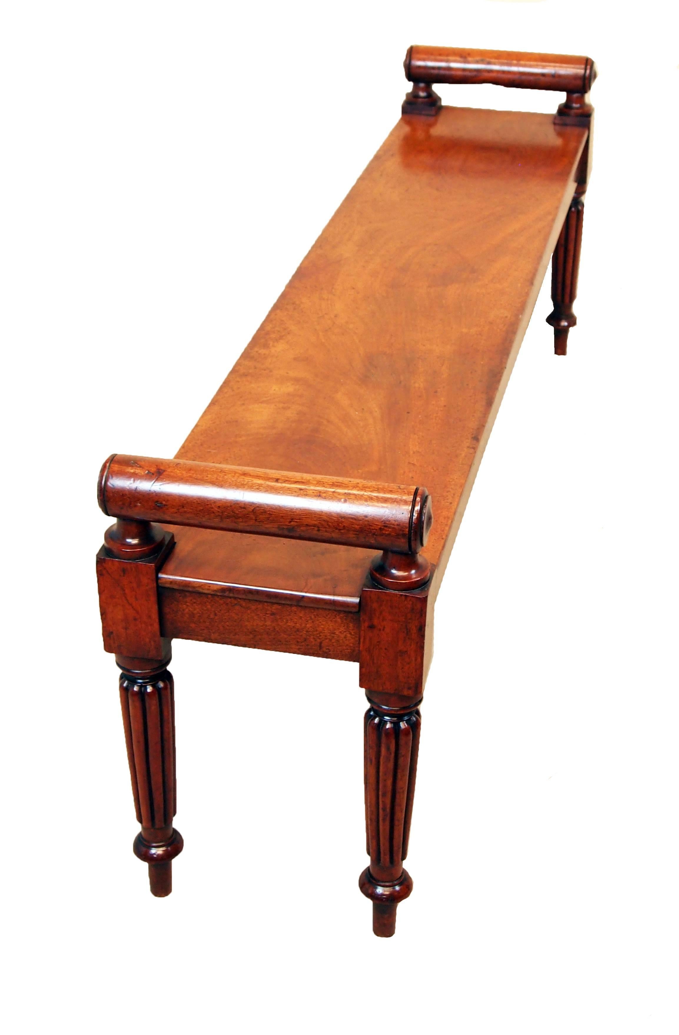 A very good quality late regency period mahogany hall bench
of large proportions having turned rolls to raised ends above
well figured seat standing on elegant reeded, turned and
tapering legs.