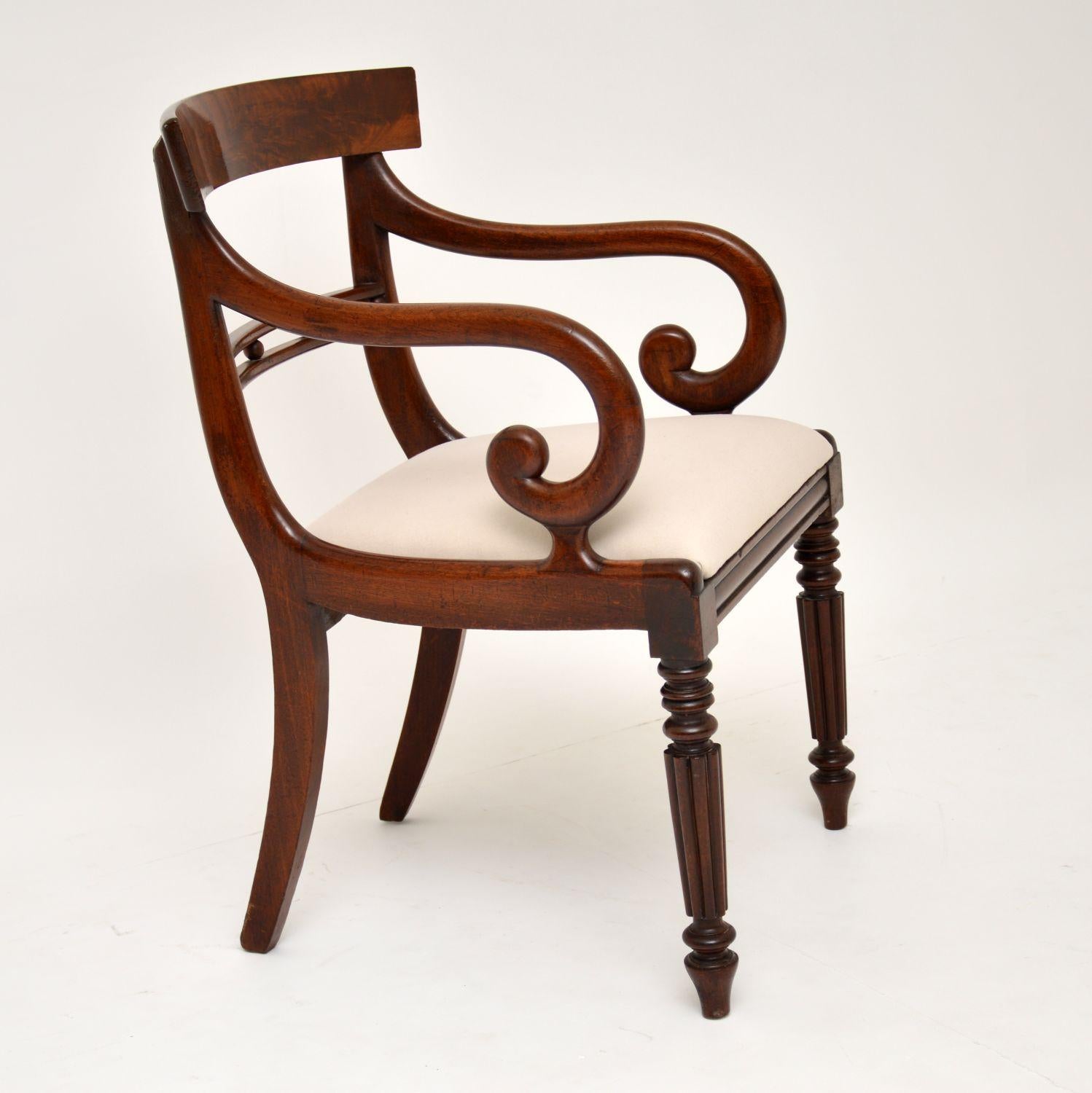Antique Regency mahogany armchair, with would be ideal for use as a desk chair. It dates from circa 1820s-1830s period and is in excellent condition. It has a flame mahogany curved back, a double rail with circular balls in-between, scroll over arms