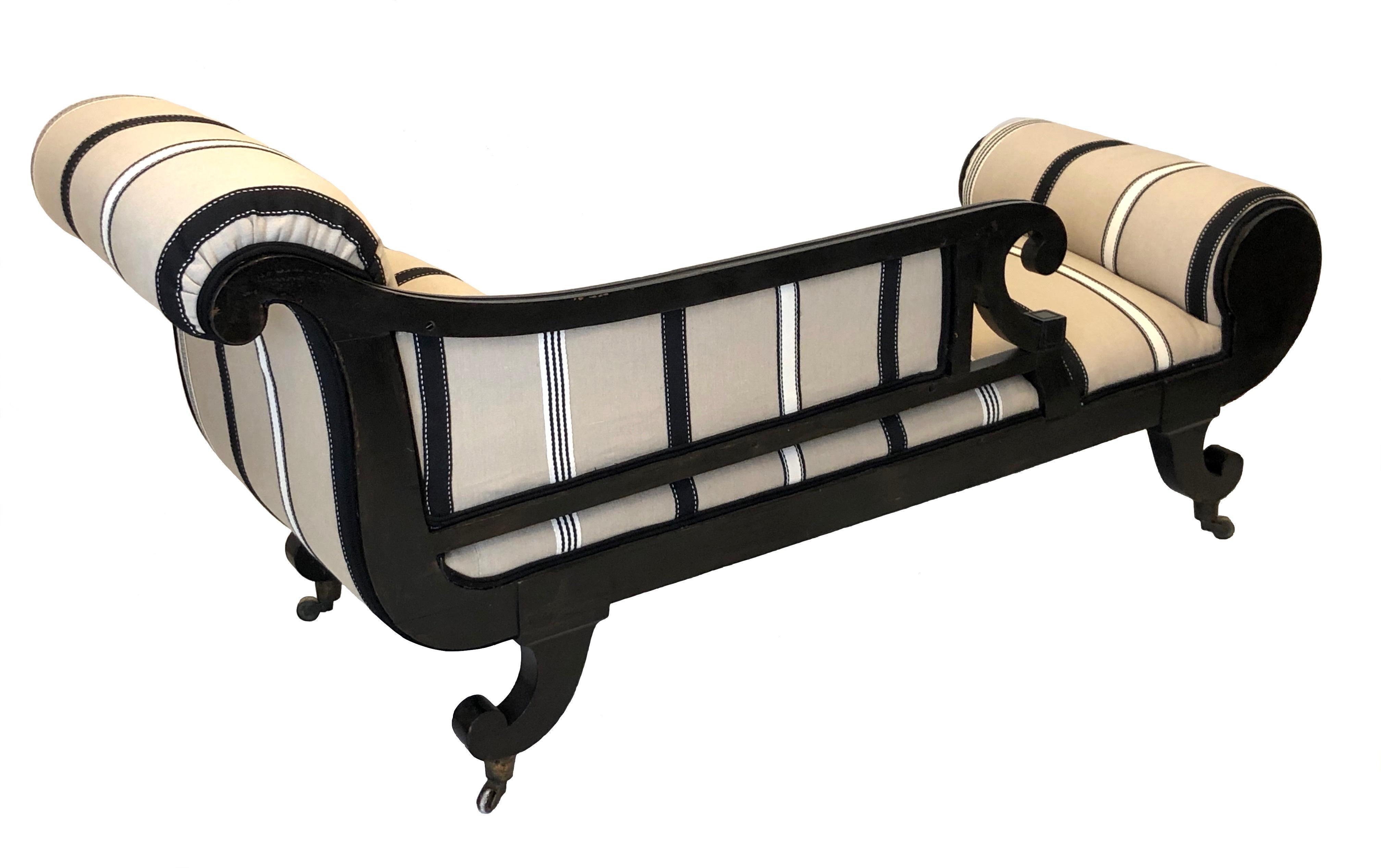 This elegant chaise longue, daybed is from the Regency period in England, circa 1815. It is made from ebonized mahogany with
finely carved decoration. The top of the curved feet at the front are finely carved with flower motives. They are standing