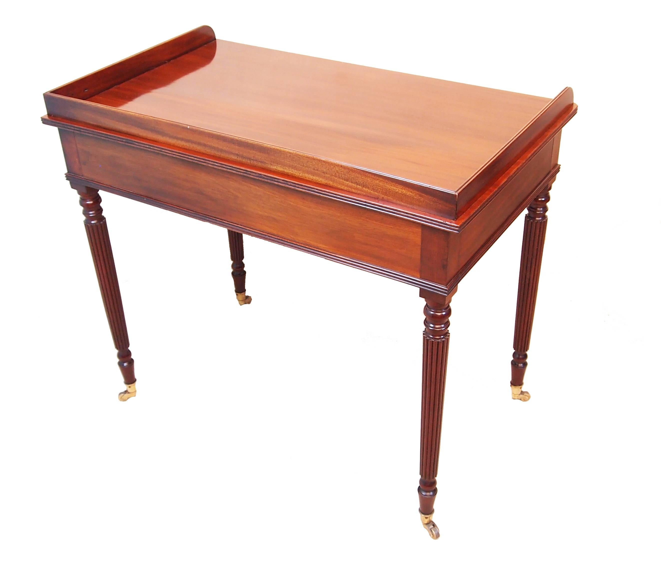 A fine quality Regency period mahogany dressing
Table having well figured gallery top above two
Frieze drawers raised on elegant turned and reeded
Tapering legs with original brass castors.