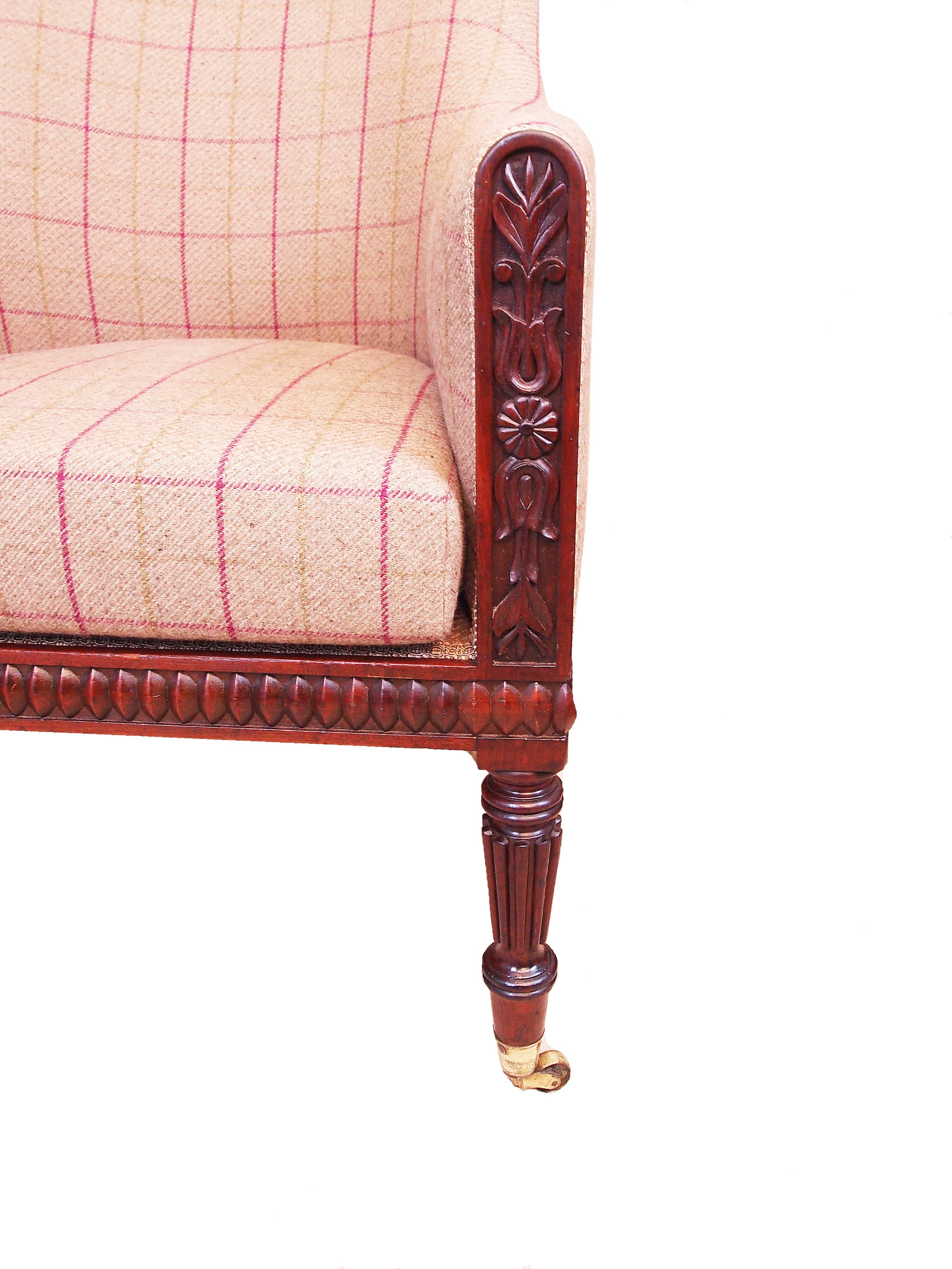 A very fine quality and extremely elegant Regency period mahogany
library armchair having crisply carved decoration to frame raised
on fine turned and reeded legs with brass cup castors.

(This is an excellent quality example of a typical regency