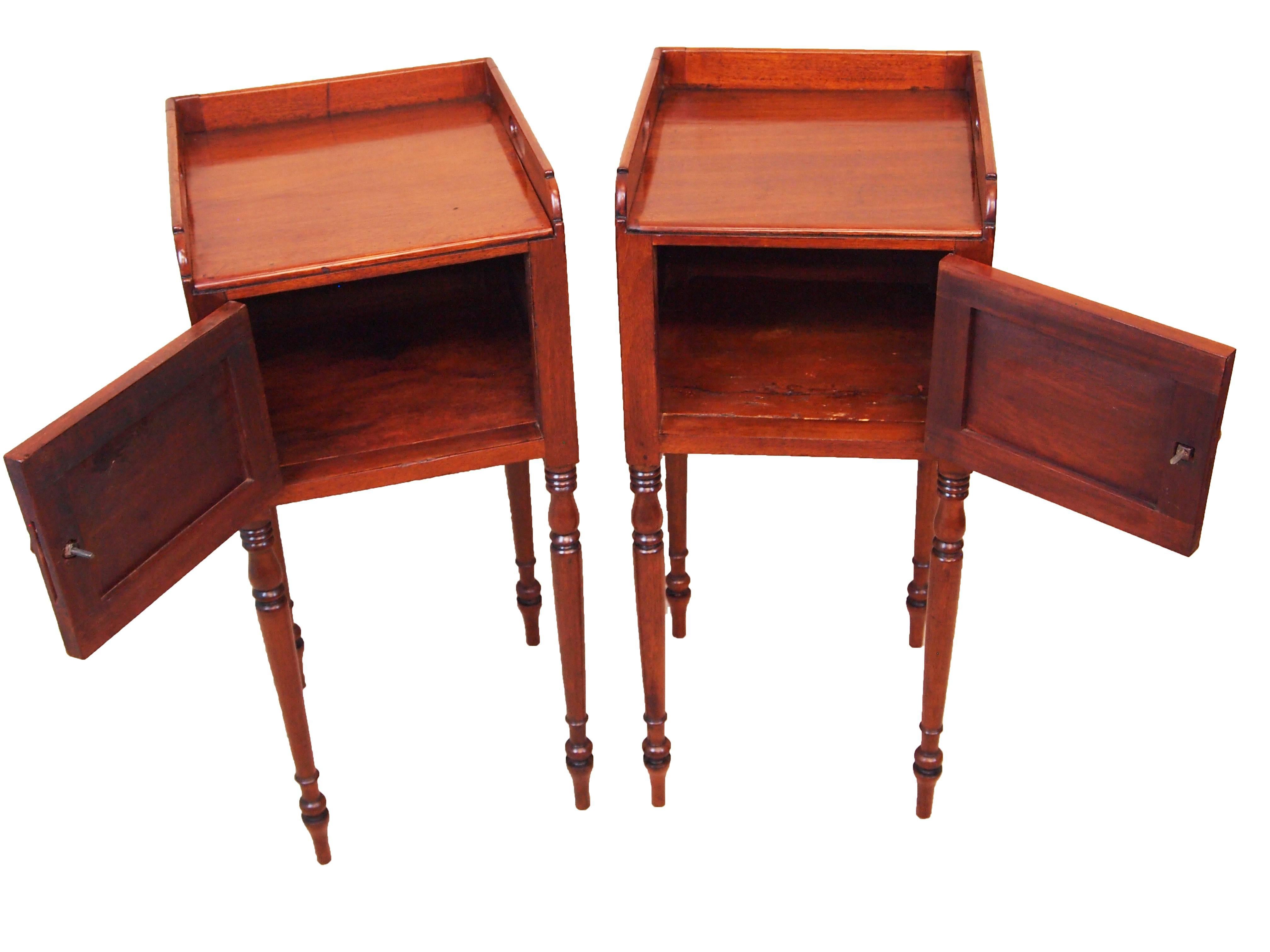 An extremely attractive pair of Regency period mahogany
bedside cupboards having well figured gallery tops
above panelled doors raised on elegant turned
tapering legs.